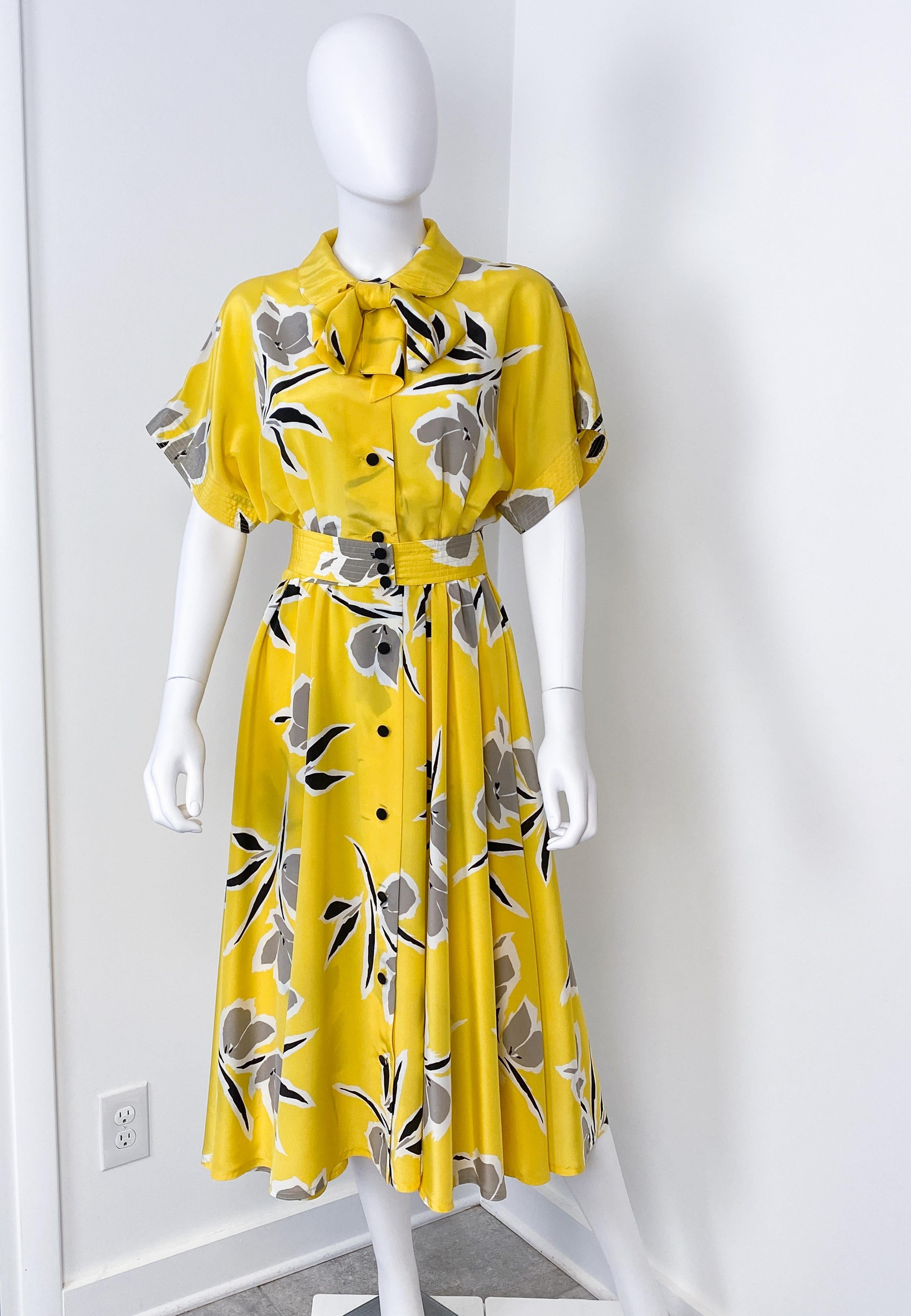 This is a superb vintage spring-summer silky polyester viscose cocktail dress from the 1980s. It is cut to a flowing silhouette typical of the era and has short sleeves. The free-flowing midi-length skirt has an elastic waist and a slash. Black