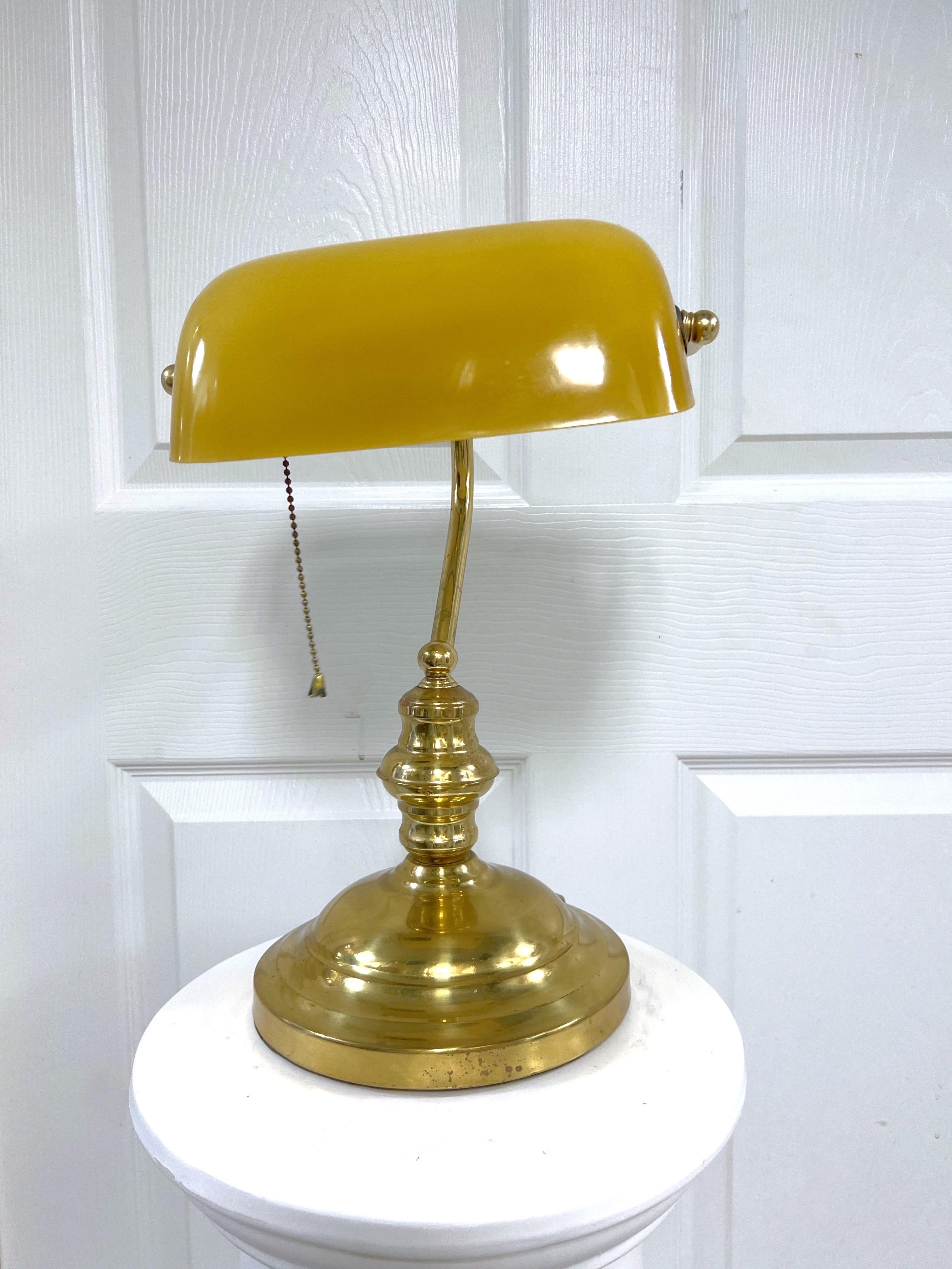 The Banker Lamp is a timeless classic of brass plating with a yellow opaline glass. An iconic design seen throughout the ages in movies, law offices, libraries and so on with a clean, modern twist.