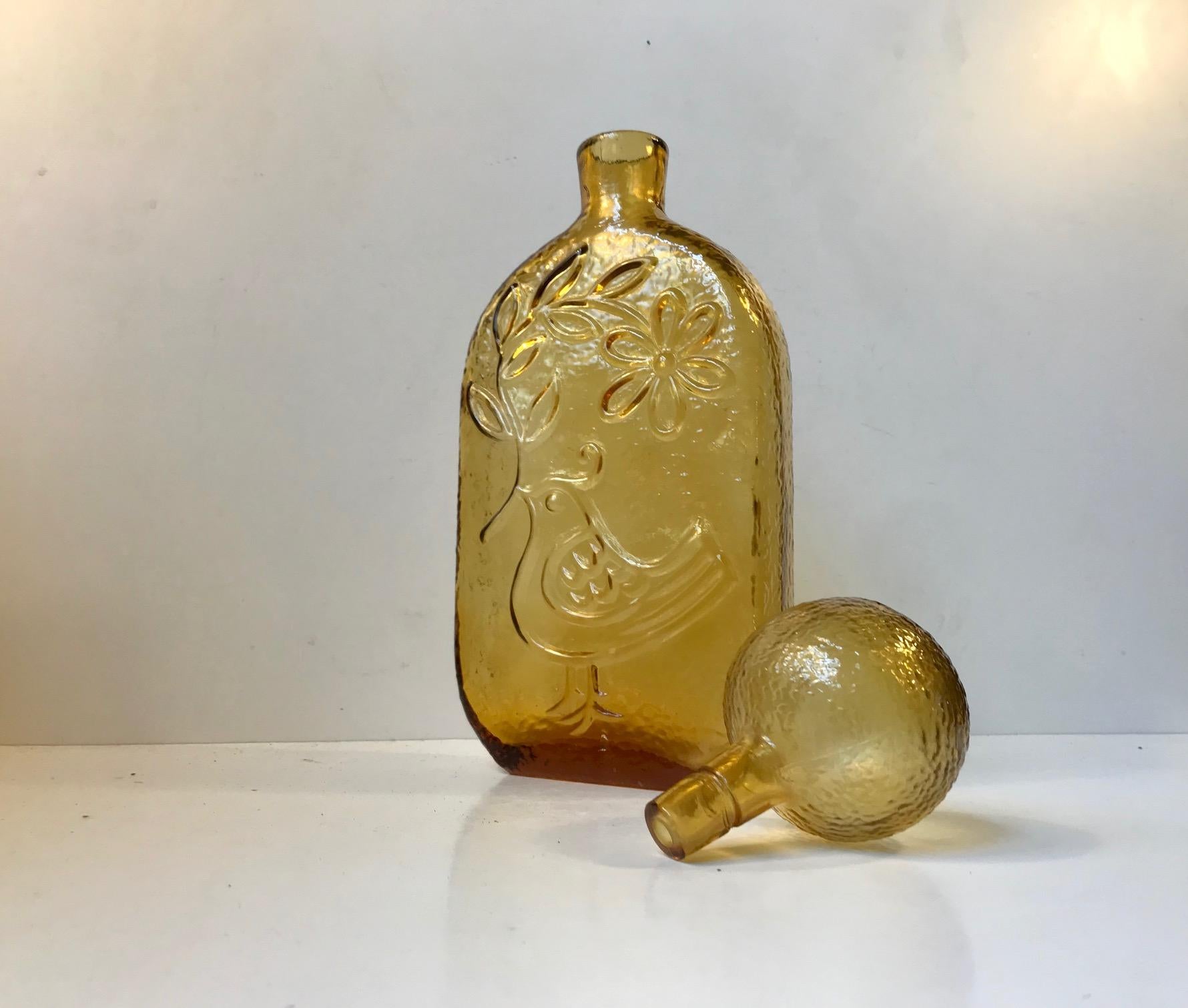 Yellow glass decanter with impressed dove and flowers in relief. Designed and manufactured by Empoli in Italy during the early 1970s. This decorative decanter can contain between 0.7-1 liter spirits or water.
 