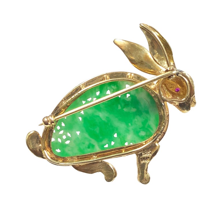 Circa 1960s 14k Bunny Rabbit Brooch, measuring 1 3/4 inches in length and 1 1/2 inches in height. The body of the Rabbit is an older piece of finely Carved Jade of Natural color, also featuring a Ruby in the Eye. Nicely detailed and extremely well