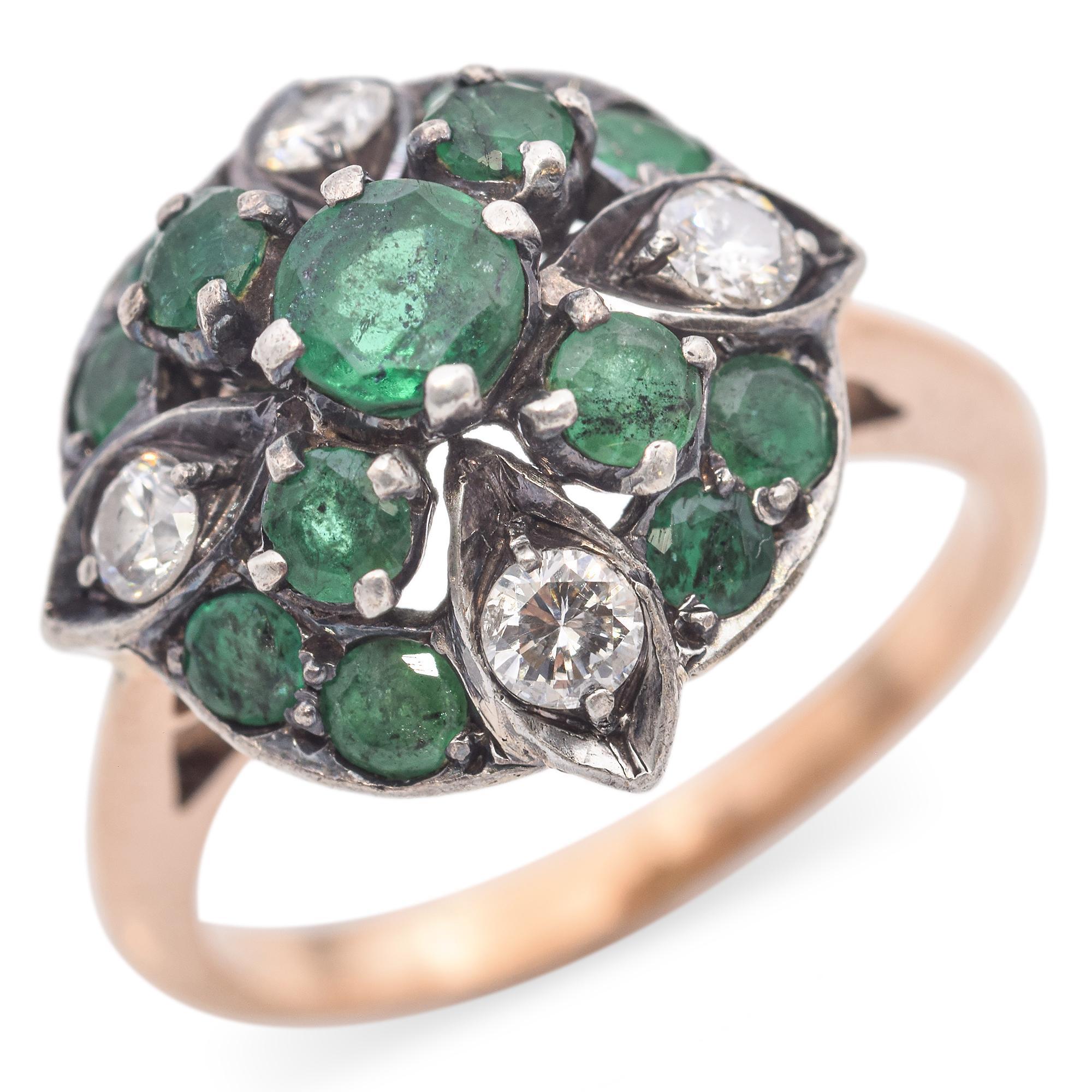 A striking vintage ring featuring a captivating arrangement of vibrant green emeralds and shimmering diamonds. The central emerald is surrounded by a halo of smaller emeralds, interspersed with diamond accents. The intricate setting showcases the