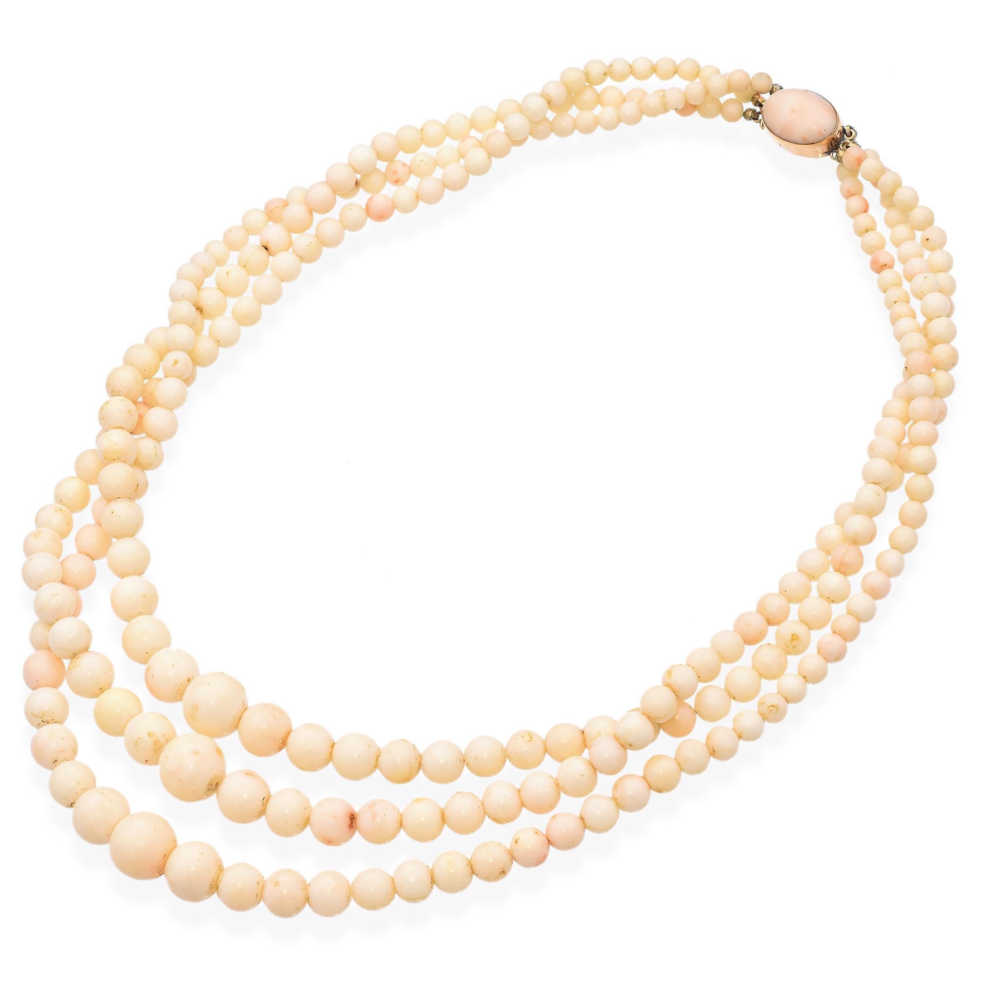 This exquisite necklace features three strands of angel skin coral beads. The beads are meticulously strung to create a harmonious and flowing design. The necklace is secured with a polished yellow gold clasp, adding a touch of warmth and