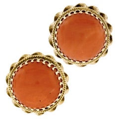 Boucles d'oreilles Omega en or jaune avec cabochon de corail rond et cadre torsadé