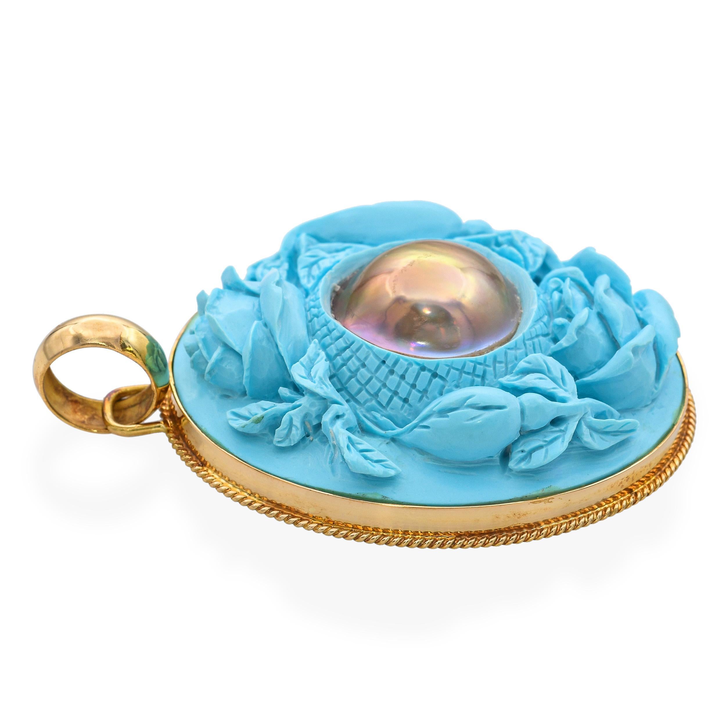 Ce pendentif antique unique présente de délicats motifs de roses sculptées, rehaussés d'incrustations de turquoises poudrées d'un bleu tendre. En son centre repose une perle de mabe lumineuse, ajoutant un point focal élégant au design. L'artisanat