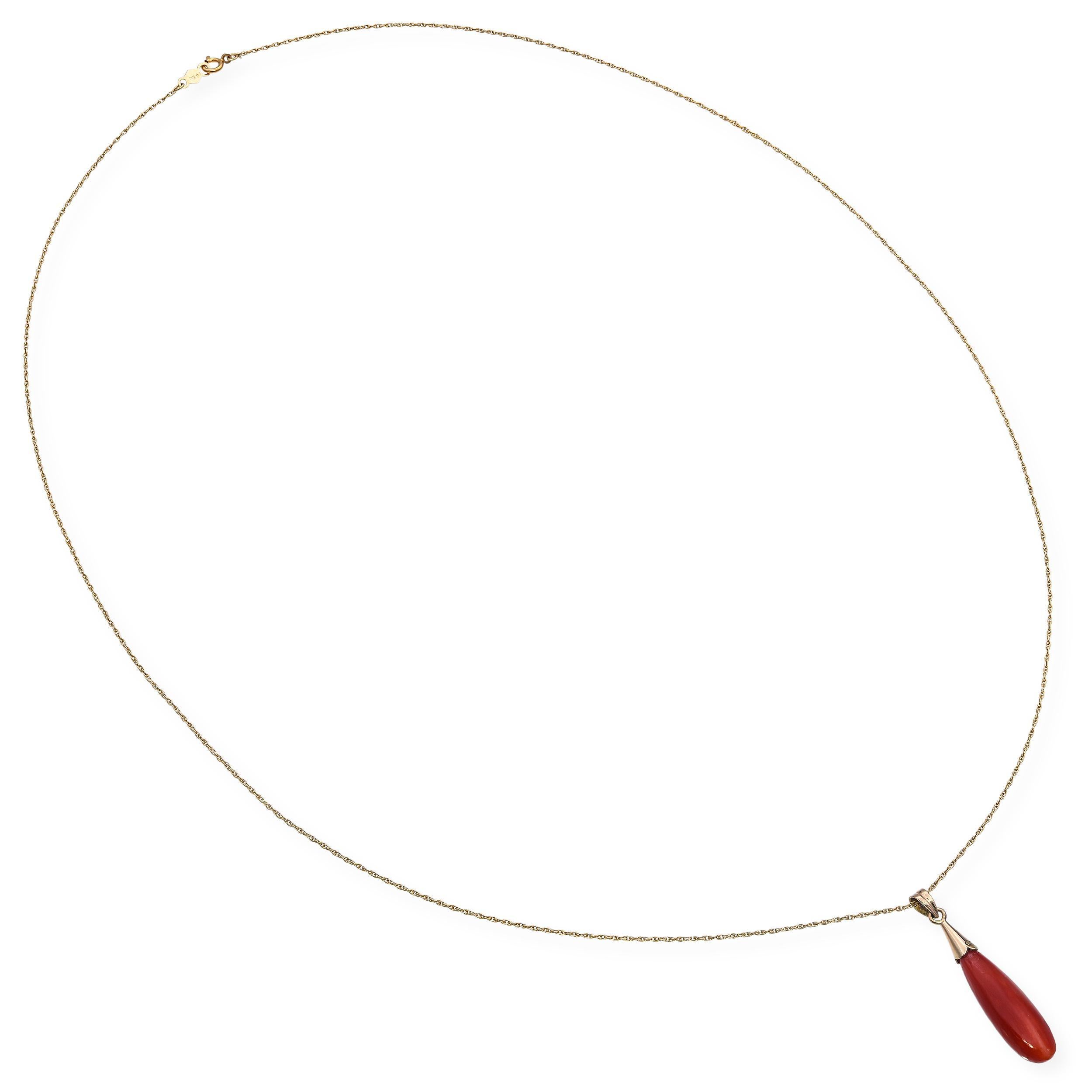 Questa elegante collana vintage presenta un ciondolo a goccia di corallo liscio e allungato in una ricca tonalità arancio-rossa naturale. Il corallo è ricoperto da un design in oro giallo lucido, sospeso a una sottile catena d'oro intrecciata che ne