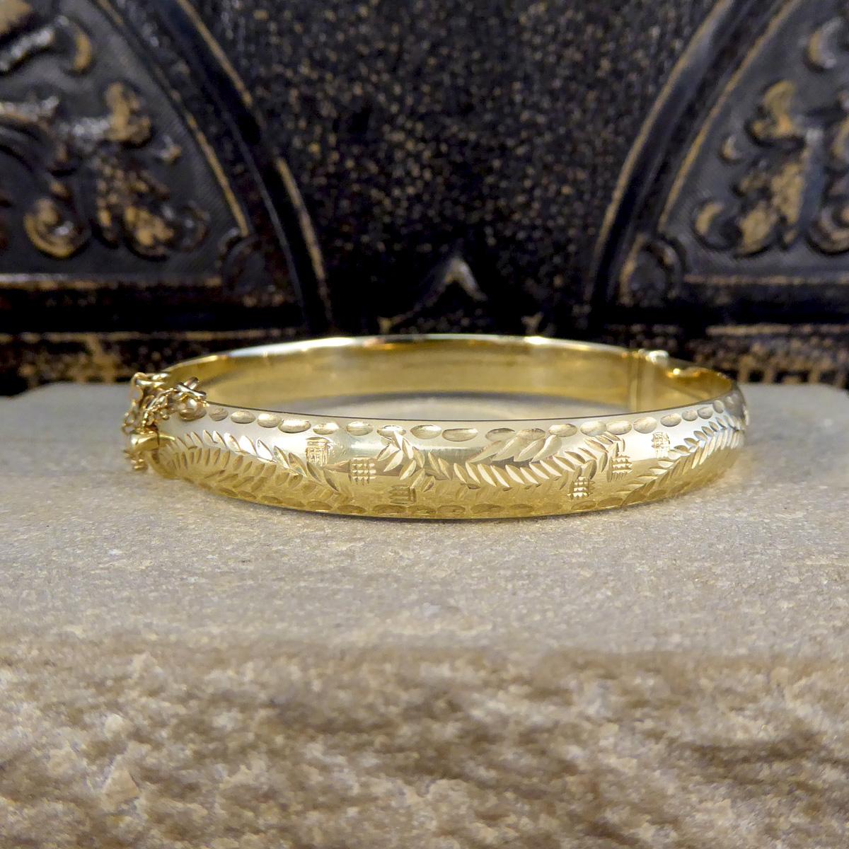 A classic and elegant vintage Gold bangle at the perfect width to be stacked or worn solo. This bangle is hollowed and hinges in the middle with a plain polished back and fully engraved detailed front, enabling it to be worn in two different ways.