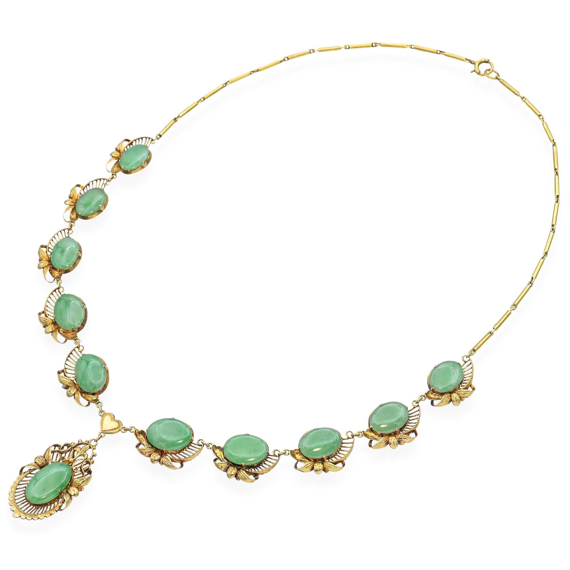 Questa collana vintage in oro giallo 12 carati presenta un centrotavola di giada splendidamente lucidato, che irradia un'eleganza naturale e ricchi toni verdi. L'incastonatura in oro caldo si integra perfettamente con la giada, aggiungendo un tocco