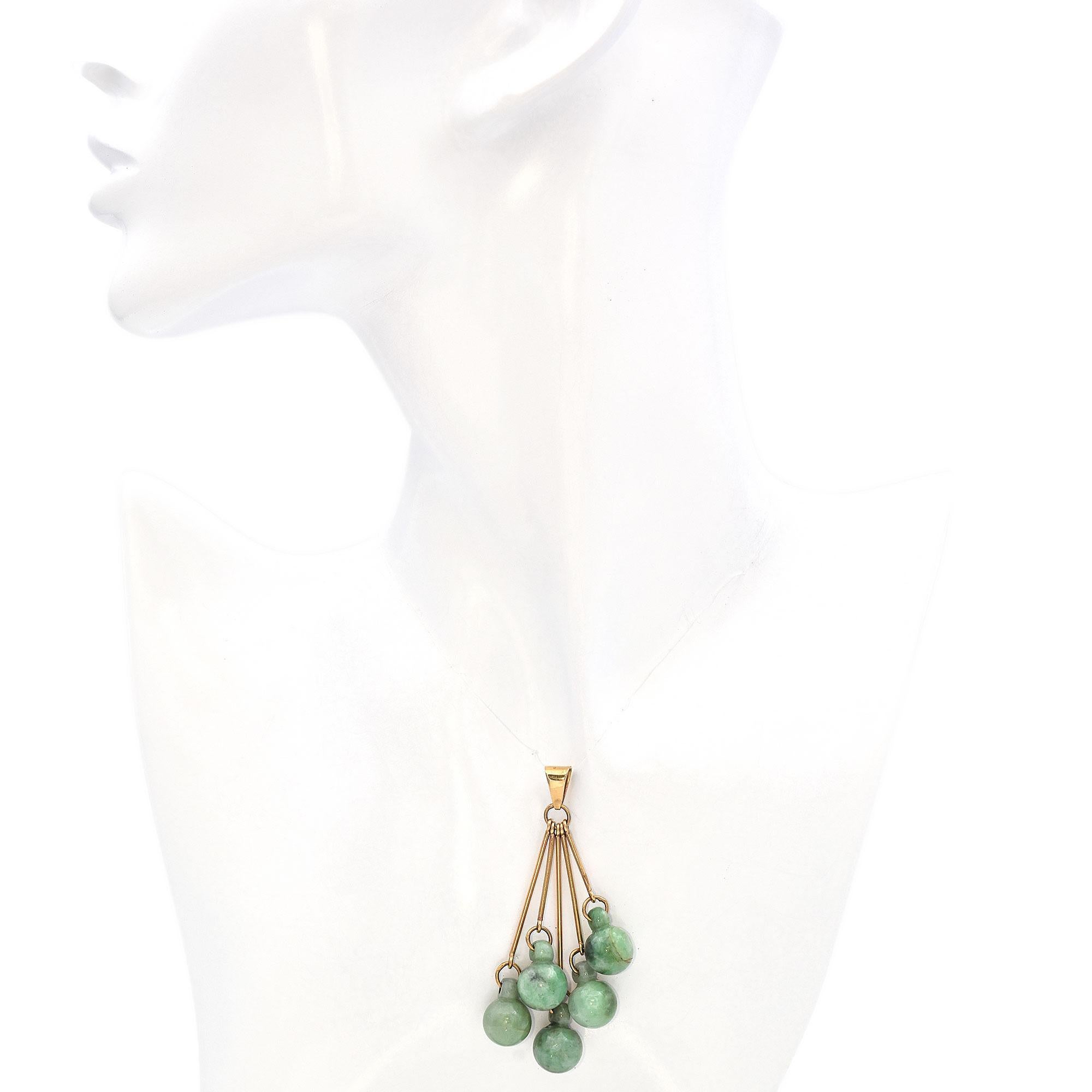Ce pendentif unique présente une série de pierres de jade d'un vert éclatant, chacune délicatement suspendue dans un arrangement en cascade, créant un contraste étonnant entre la teinte verte profonde du jade et l'éclat chaud de l'or. Le design