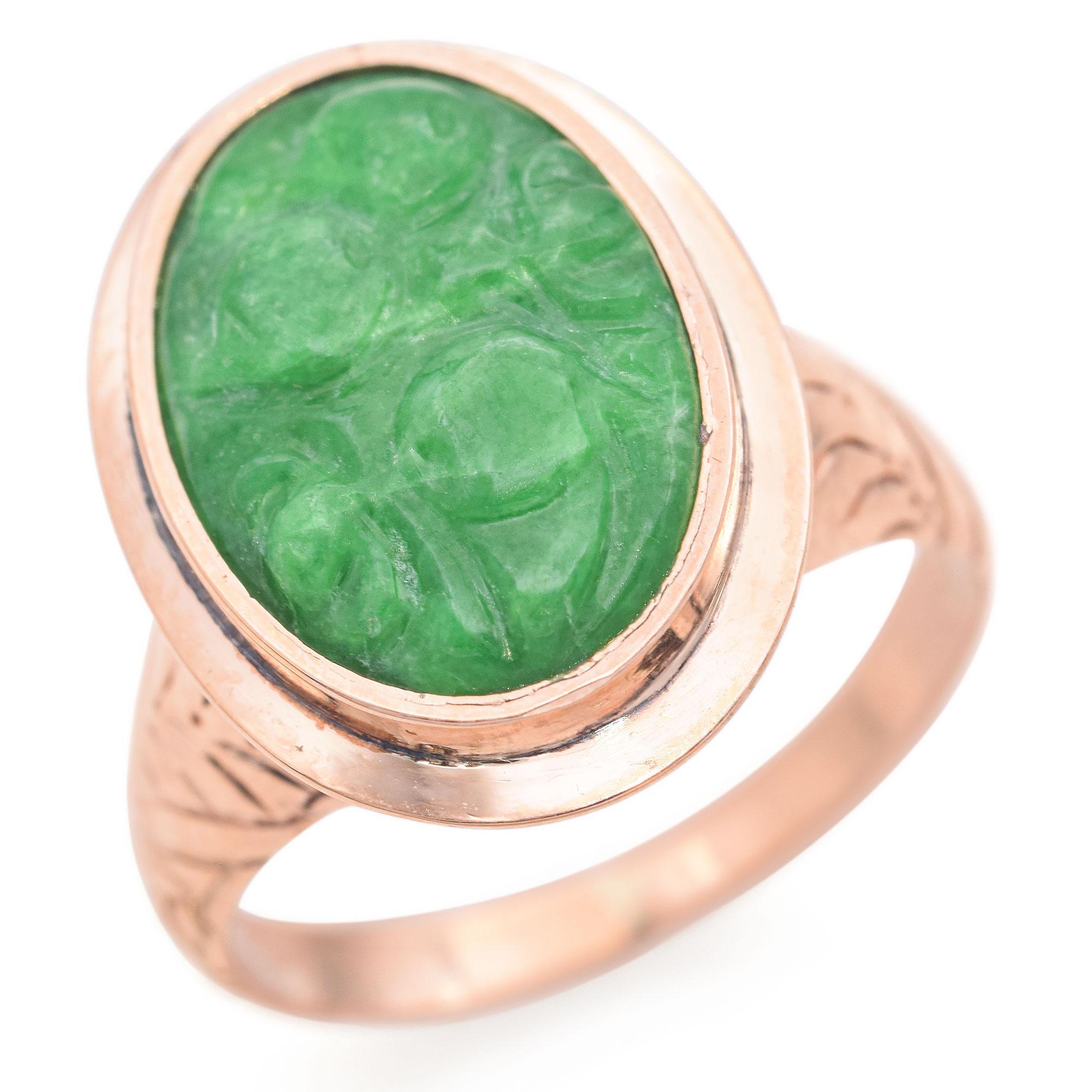 This exquisite ring features a vibrant green jade stone, intricately carved and set in a smooth 12k gold bezel. The band showcases subtle leaf motif engravings, adding a touch of sophistication. The ring is lightweight and comfortable, making it a