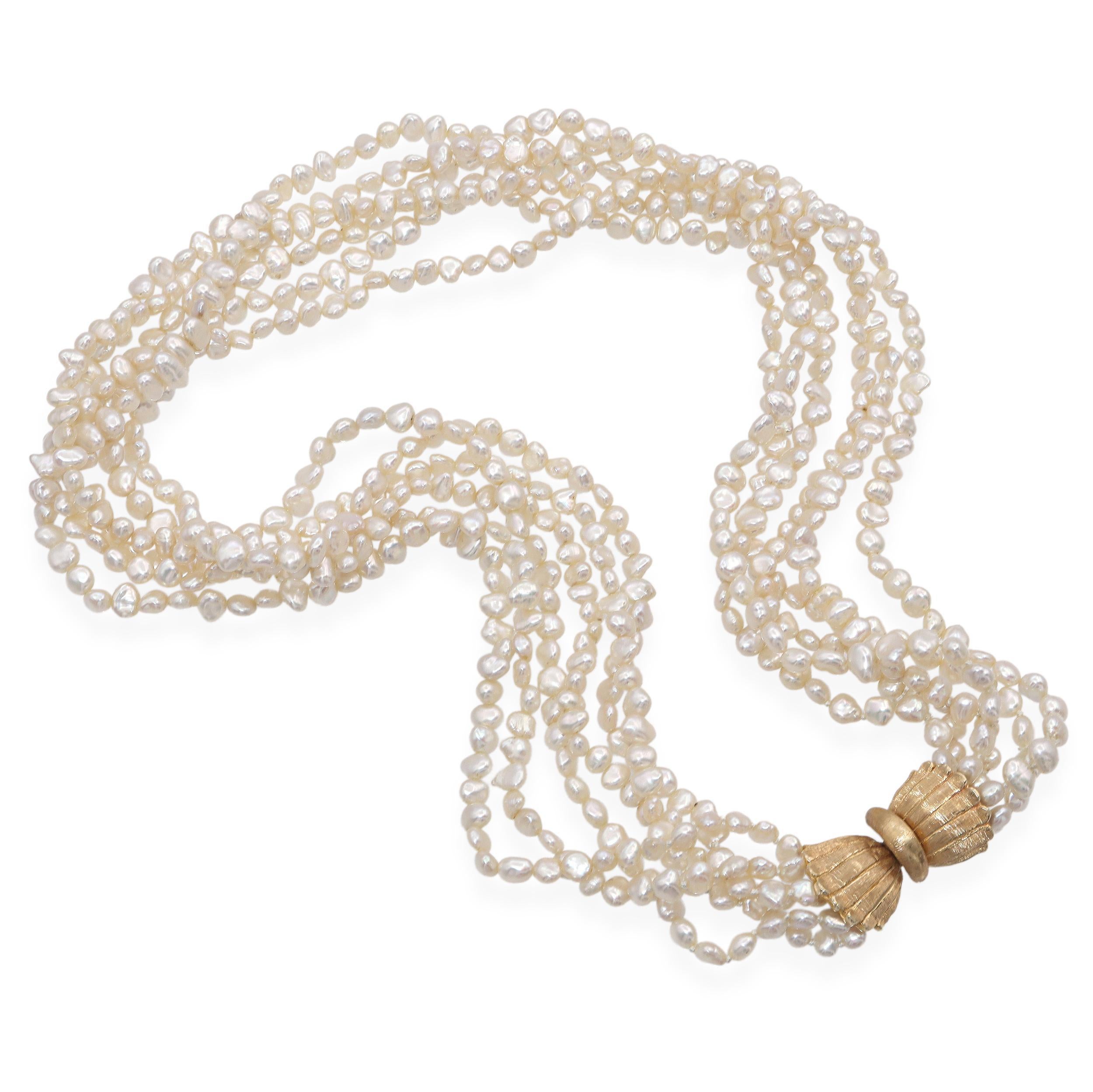 Questa elegante collana di perle d'acqua dolce coltivate a più fili è fissata con una splendida chiusura a fiocco scanalato. La chiusura è marchiata 14k, ma i test indicano che si tratta di oro giallo 13k, il che lo rende un pezzo unico e