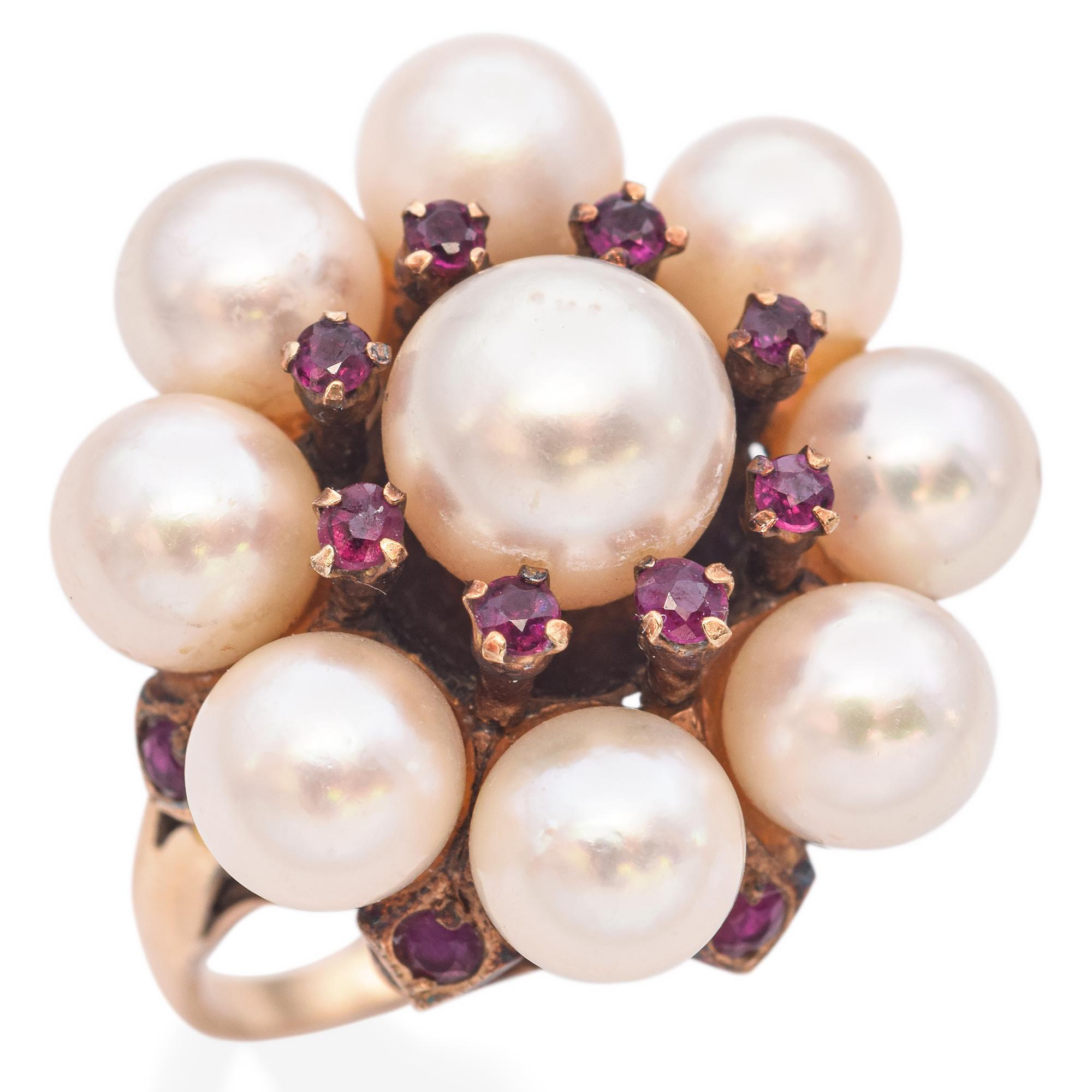 A striking vintage ring designed in a cluster motif, featuring a central large pearl surrounded by smaller pearls and vibrant round cut rubies, set in a gold mount.
Some noticeable glue underneath a few pearls.

Weight: 8 grams 
Stone: Center Pearl