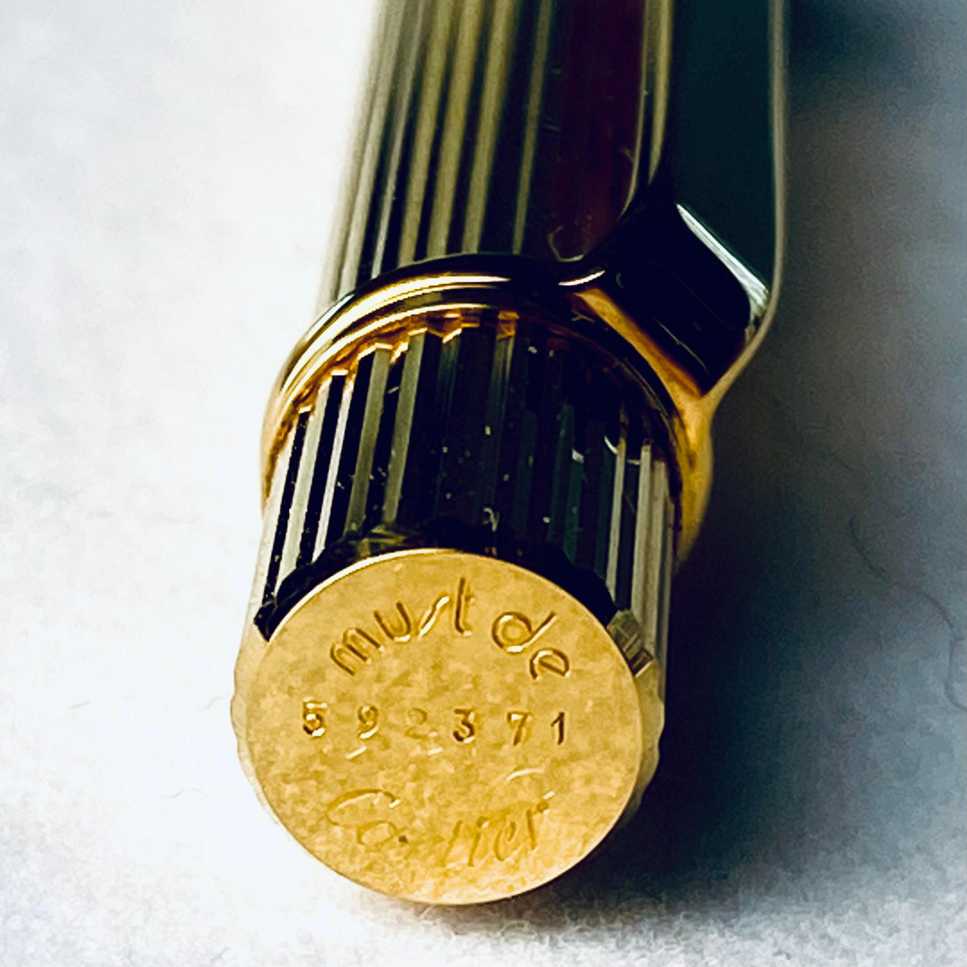 Voici le stylo à bille Vintage plaqué or jaune de Cartier - une pièce d'élégance intemporelle avec ses rayures en relief et le poinçon emblématique Must de Cartier. Cet instrument d'écriture exquis est parfait pour ceux qui apprécient à la fois le