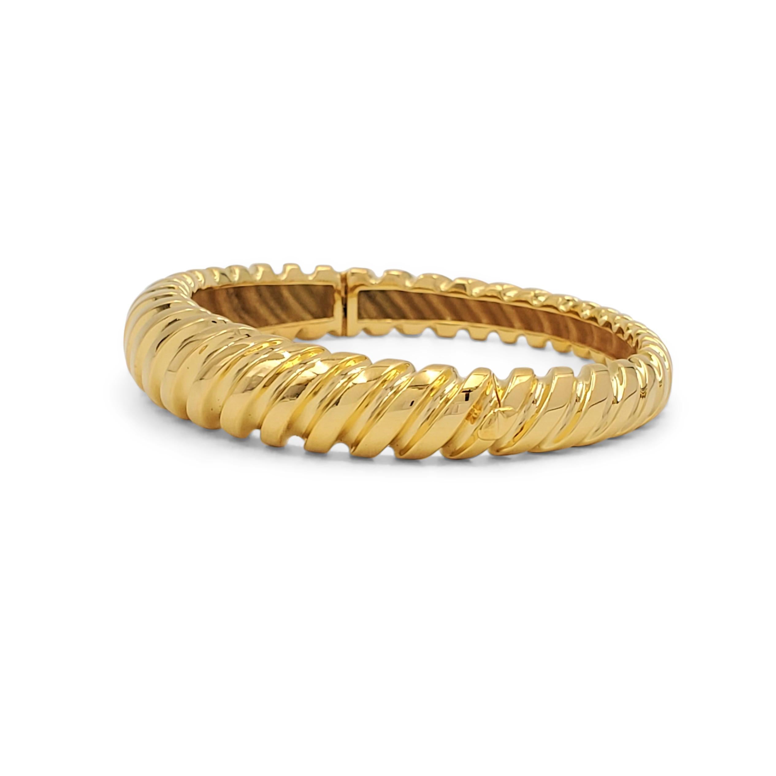 A wearable hinged bangle bracelet crafted in 18 karat yellow gold. No makers marks or hallmarks present. The bracelet is not presented with the original box or papers. CIRCA 1990s. 

Bracelet Size: Will fit up to 7-inch wrist
Box: No
Papers: No