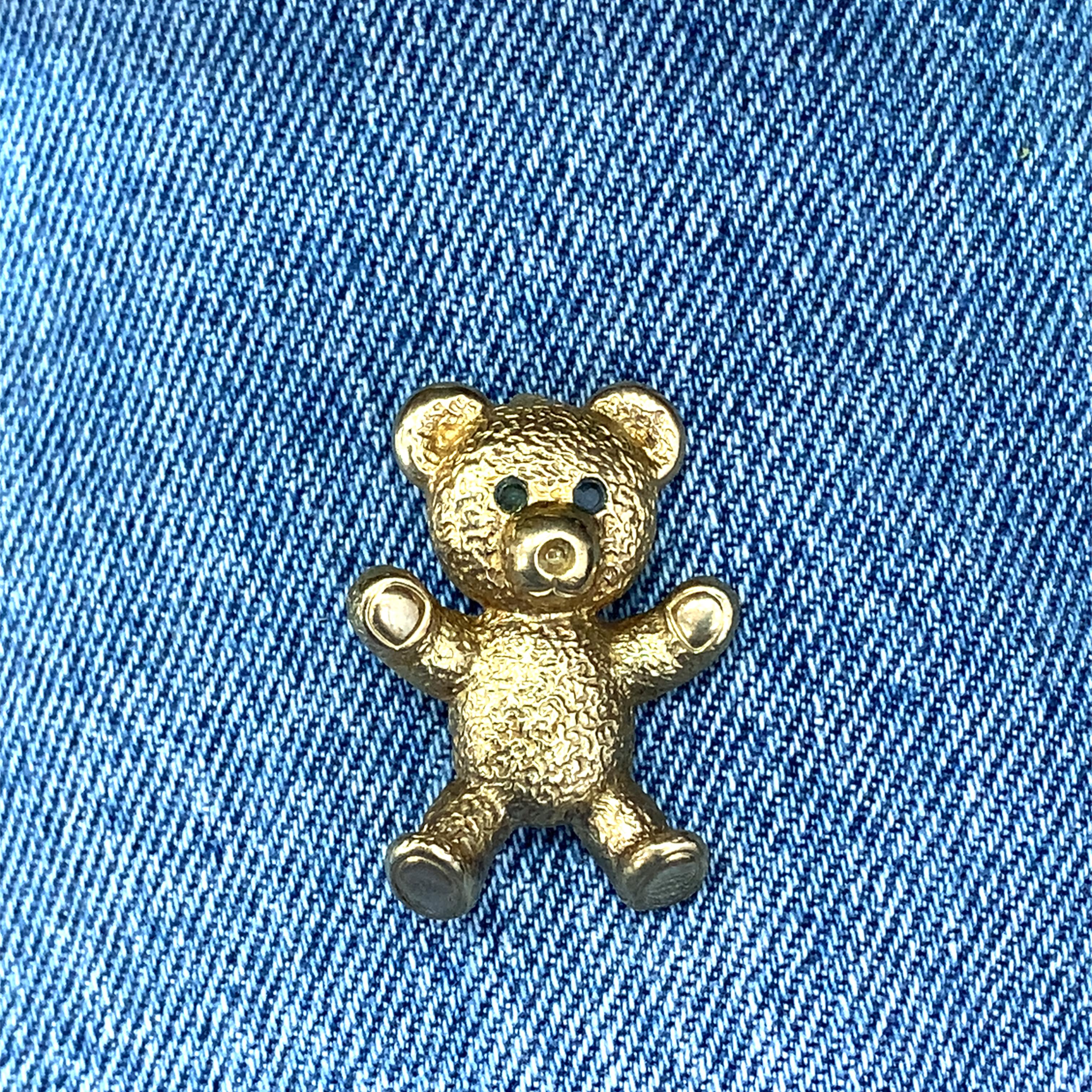 Mit dieser charmanten Teddybär-Brosche im Vintage-Stil können Sie Ihren Stil aufwerten. Gefertigt in warmen  Dieses skurrile Accessoire aus 9 Karat Gelbgold mit dunklen Smaragdsteinen verleiht jedem Ensemble einen Hauch von verspielter Eleganz. Ein