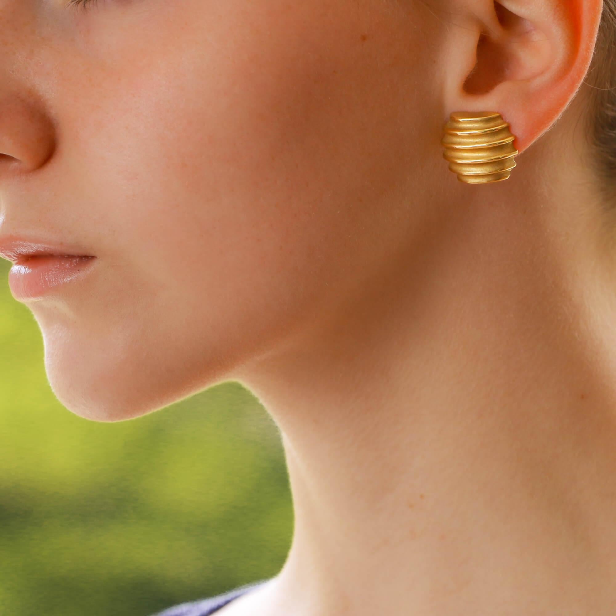 A lovely pair of barrel shaped - almost like honey pots, vintage 18 carat yellow gold earrings. The earrings have a sweet and simple design making them a perfect contender for an everyday pair. They are secured with a post and clip fitting. 
 
For