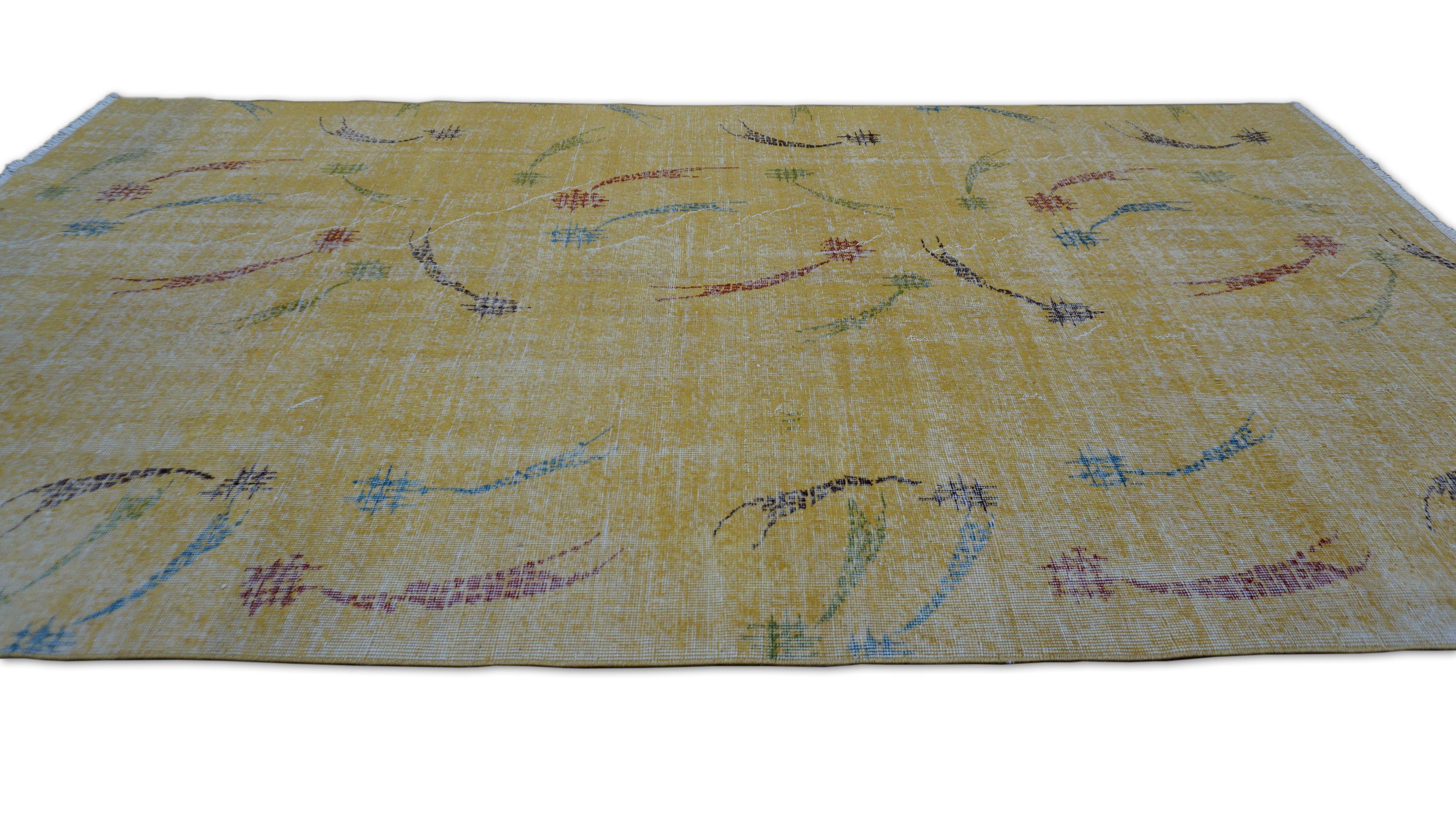 Esta alfombra de lana anudada a mano presenta un luminoso campo amarillo dorado adornado con un caprichoso estampado de abstractos aerosoles florales y líneas curvas en suaves tonos amarillos, azules, verdes y ciruela. Combinando la sensibilidad