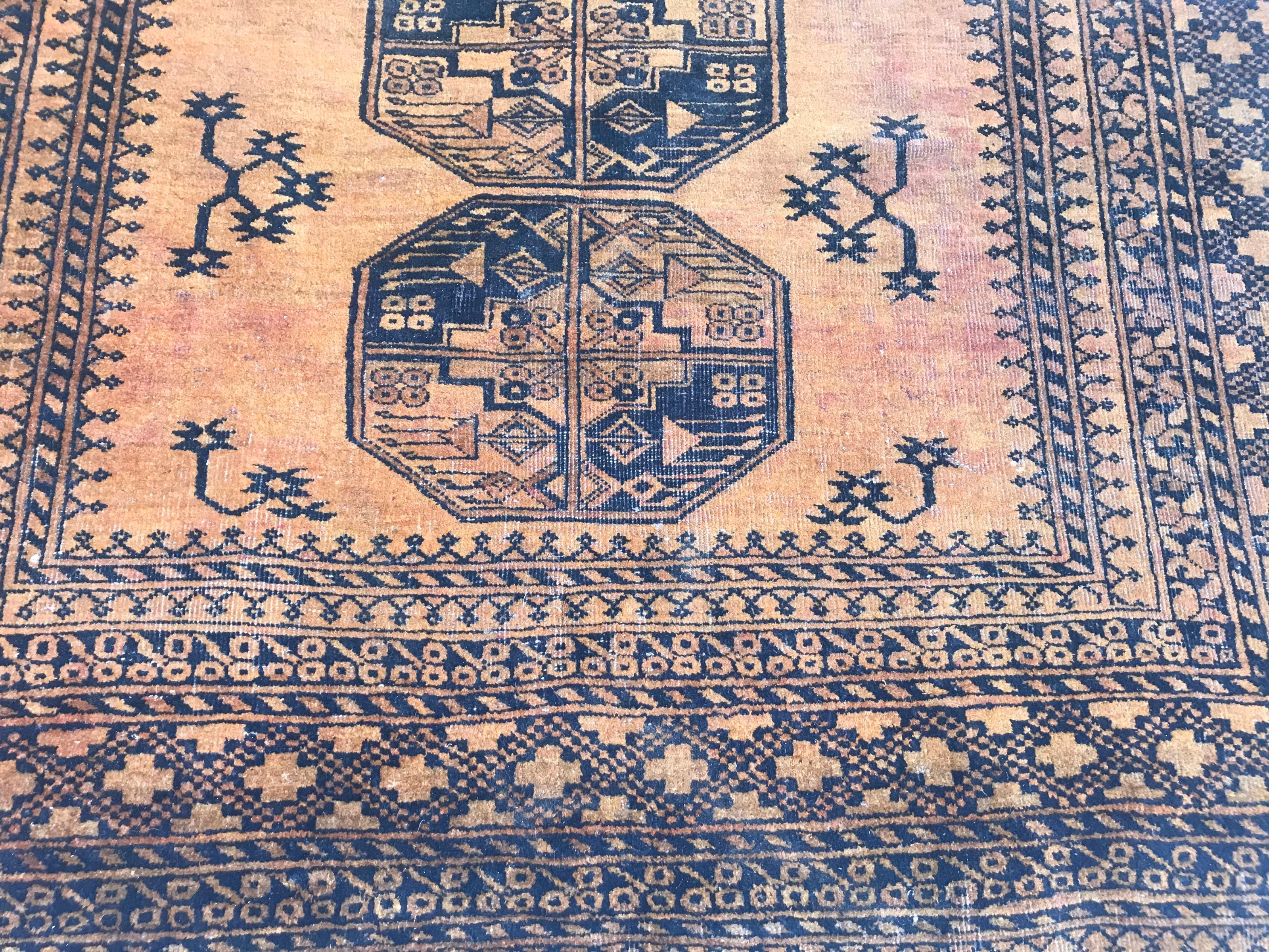 A mid-20th century Turkmen Afghan rug with beautiful Gul design and a yellow near to orange field color, entirely hand knotted with wool velvet on wool foundation.