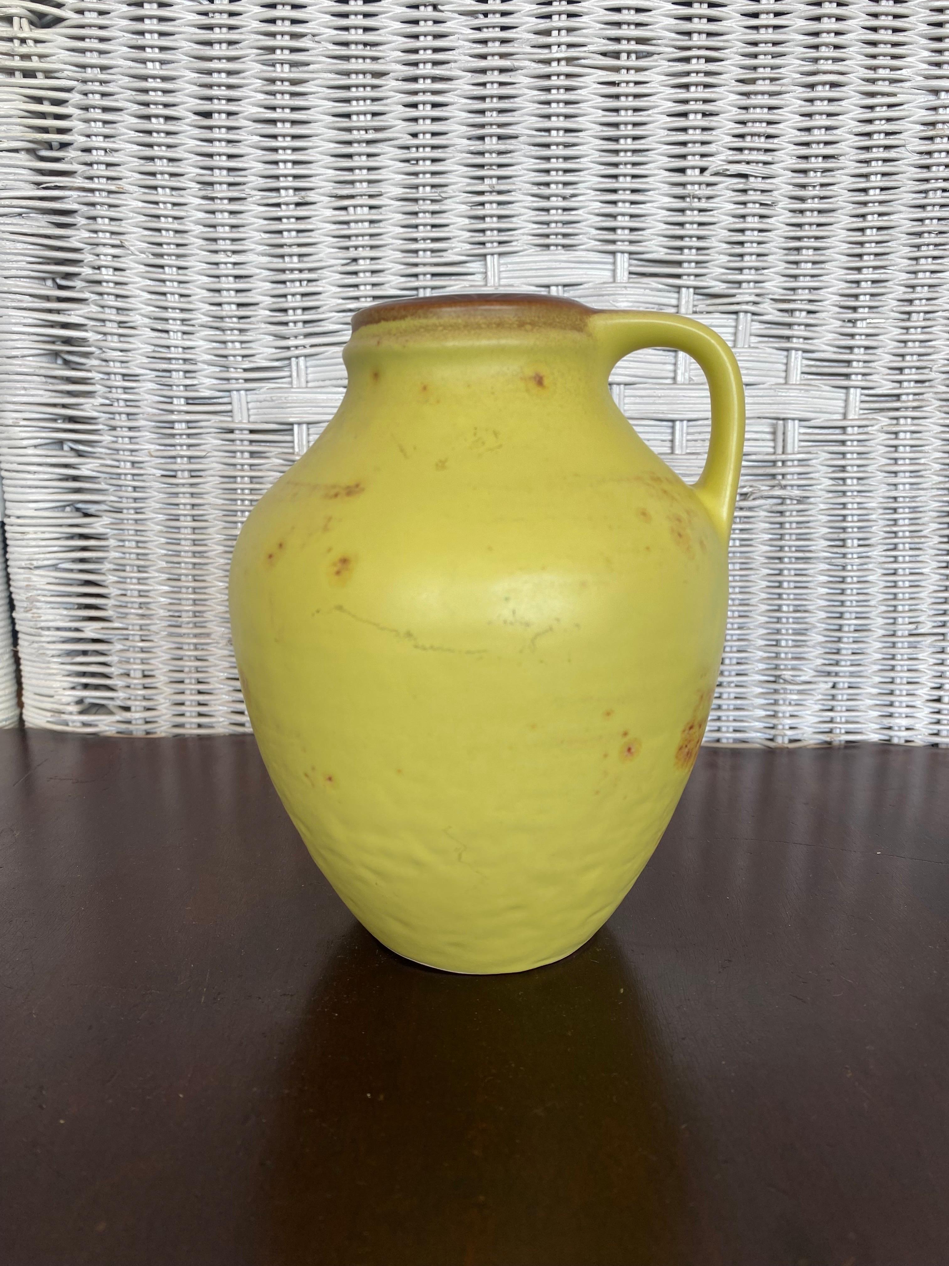 Gorgeous little vase, carafe, urn or vessel with handle in mustard yellow with brown accents. The vase is marked on the bottom with W-GERM. C874-15, with the first part referring to the former country West-Germany.

This beautiful little gem is in