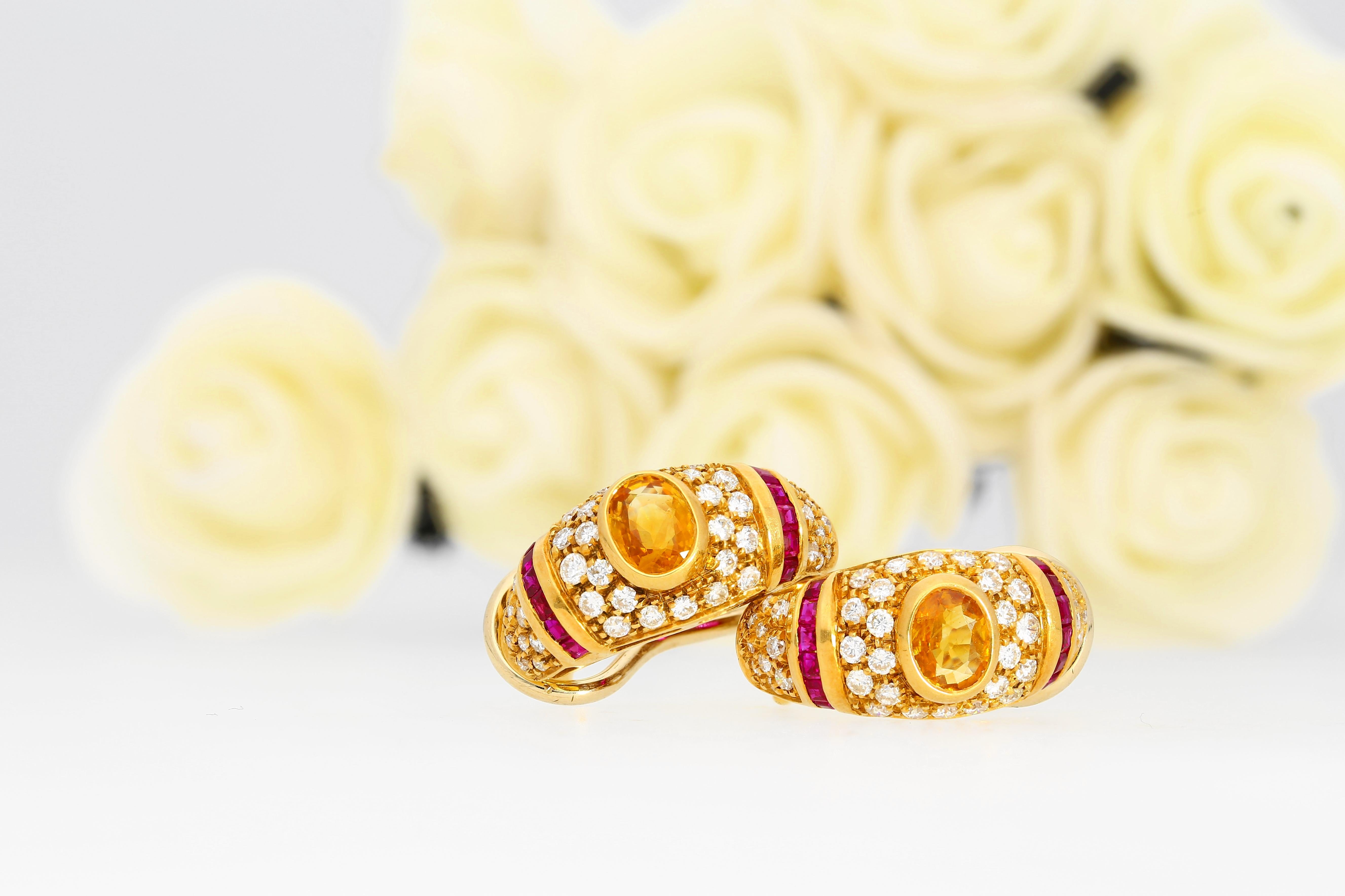 Centering 2 Oval-Cut Yellow Sapphires
Accented with 24 baguette-cut rubies and 88 round-brilliant cut diamonds
Set in 18k Yellow Gold - 8 grams
