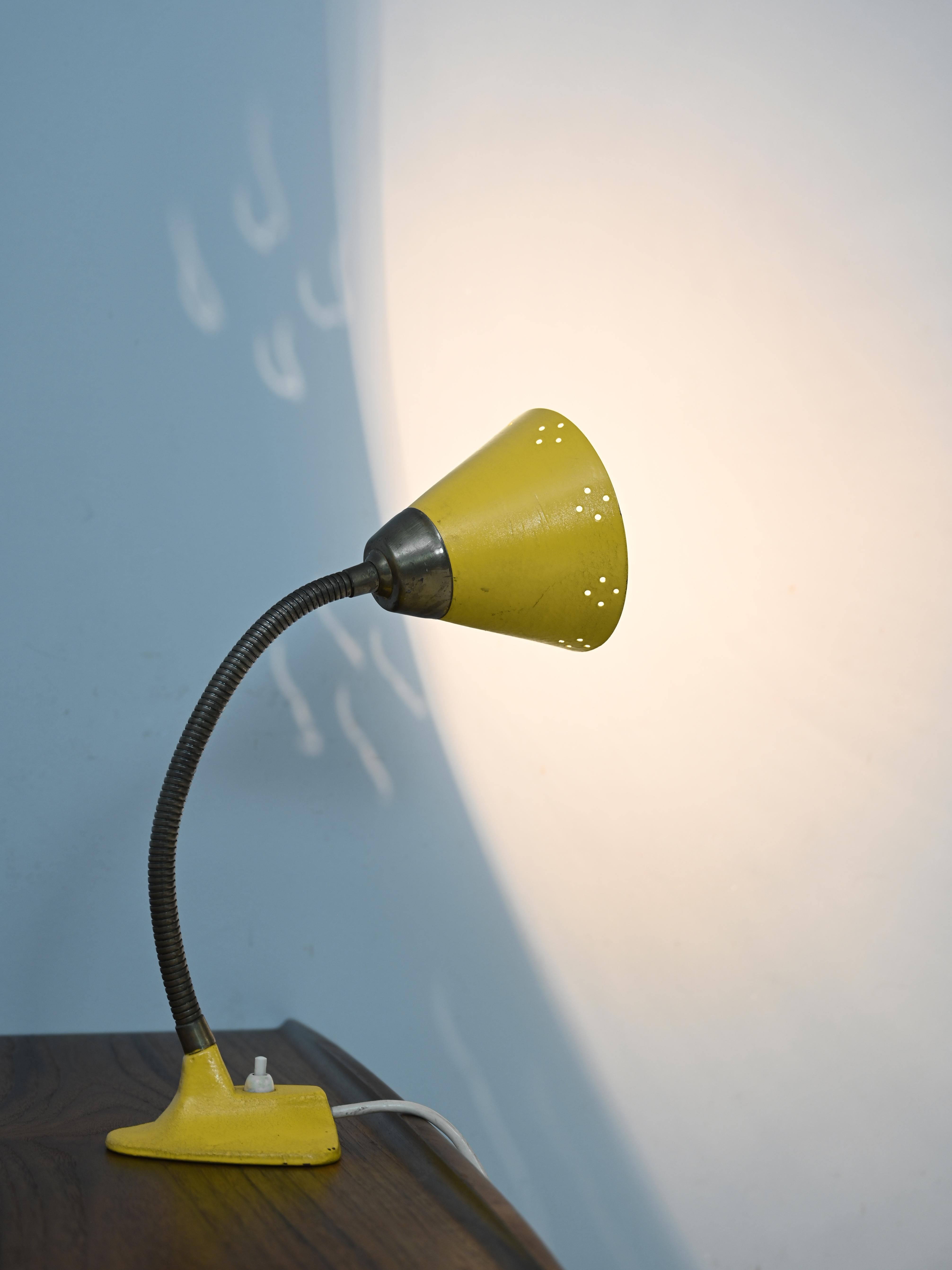Original vintage scandinave abat-jour.

Cette lampe particulière retrace le style du milieu du siècle. Il se distingue par sa tige en métal
doré et l'abat-jour qui a des petits trous dans une forme géométrique. La couleur jaune le