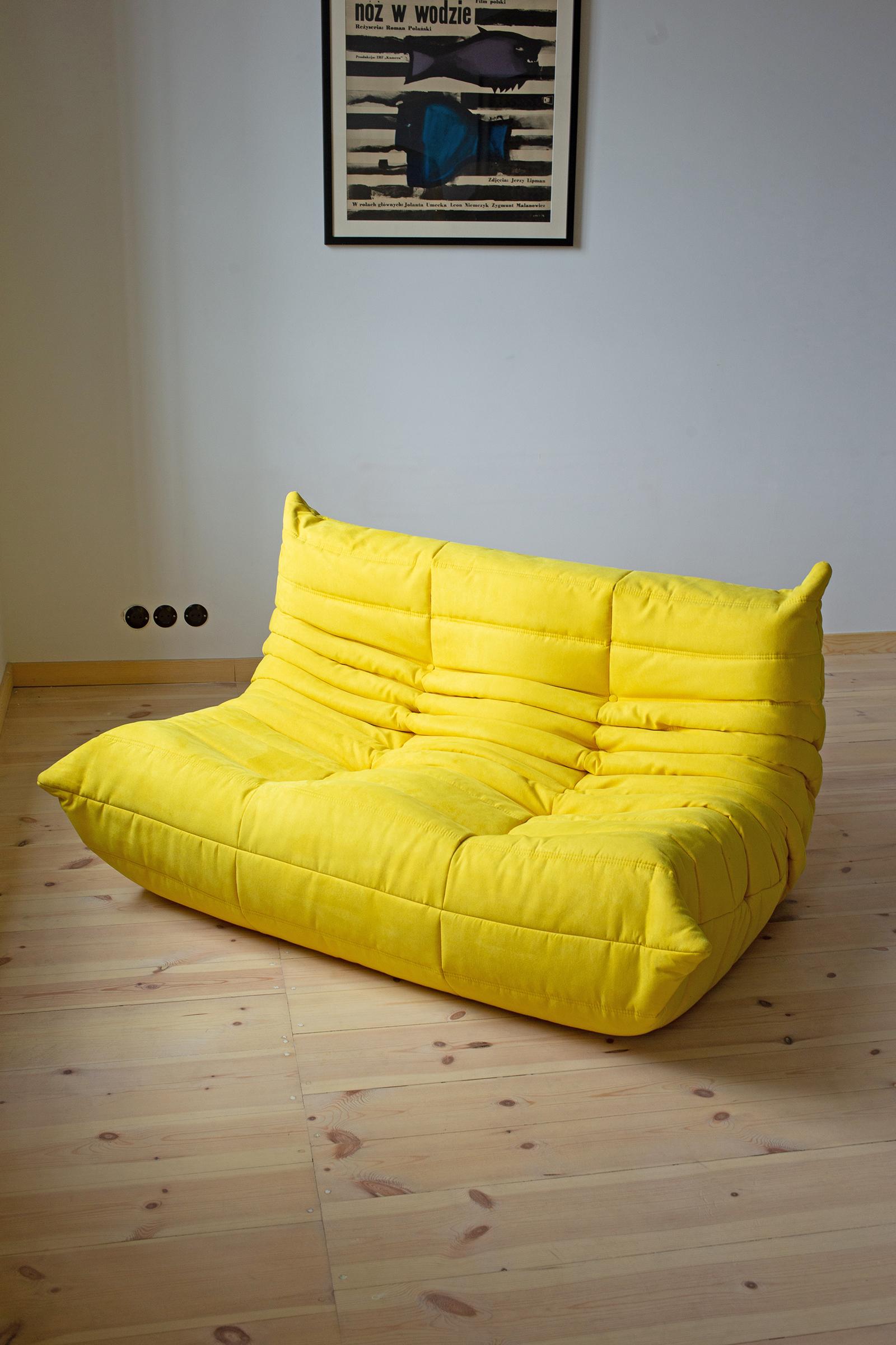 This Togo living room set was designed by Michel Ducaroy in 1973 and was manufactured by Ligne Roset in France. It has been reupholstered in high quality yellow microfiber and is made up of the following pieces, each with the original Ligne Roset