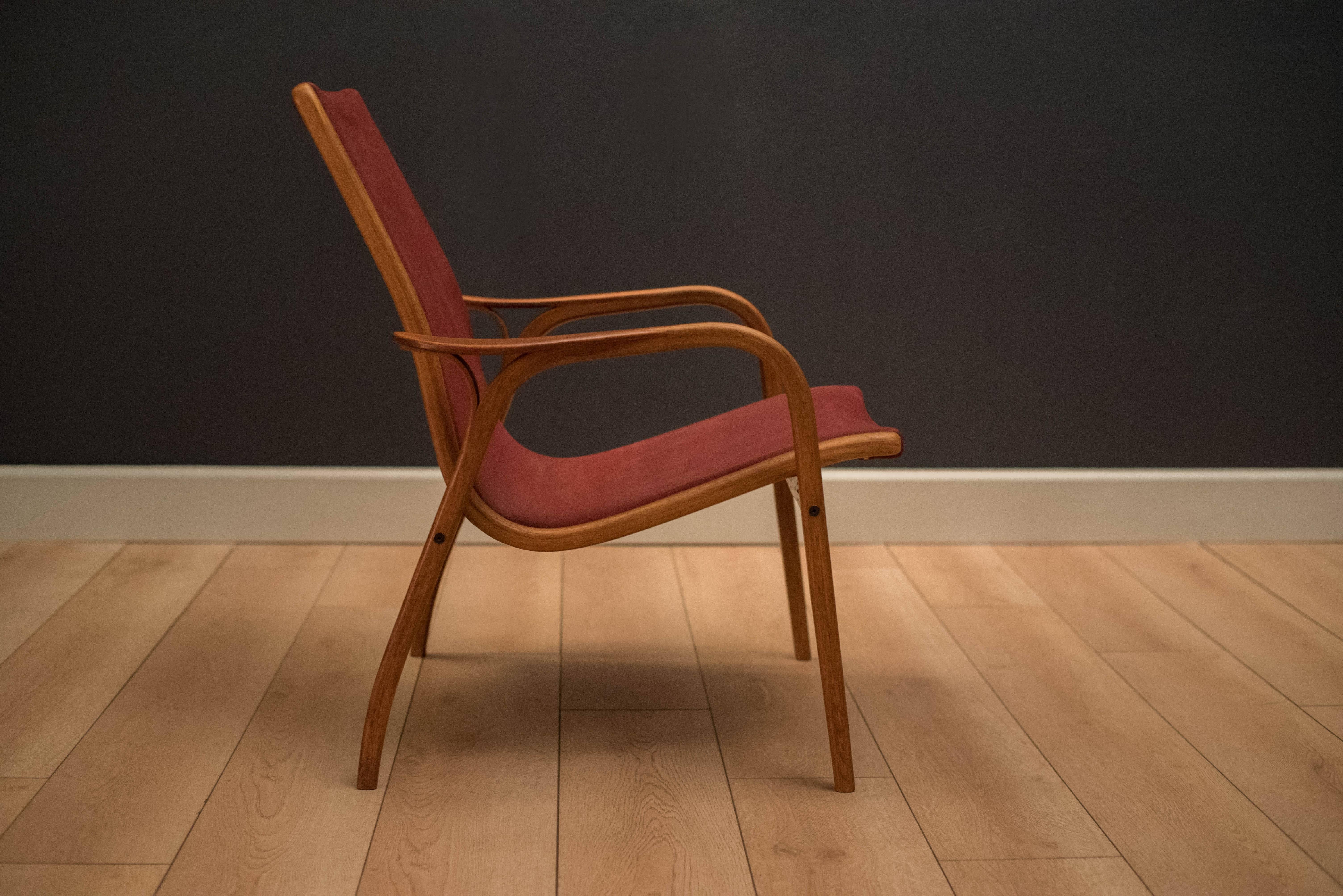 Mid century low back Laminett lounge chair designed by Yngve Ekström for Swedese. This piece displays a sculptural oak frame with contrasting teak arms. Retains the original suede fabric in burgundy red.