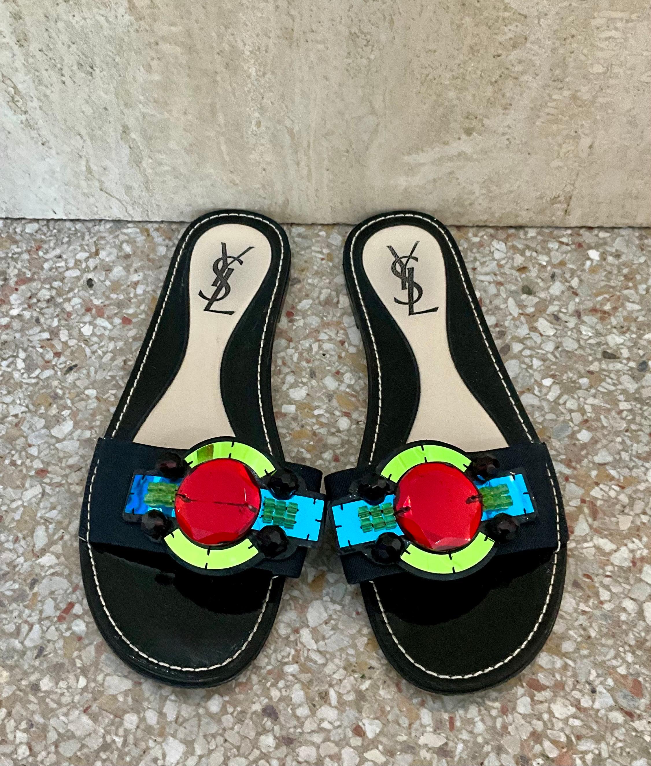 The Vintage YSL Paris Black Gem Embellished Sandals are an iconic pair of luxury footwear, showcasing Yves Saint Laurent’s renowned craftsmanship and high fashion aesthetic. 

Yves Saint Laurent (YSL) – A legendary fashion house known for its