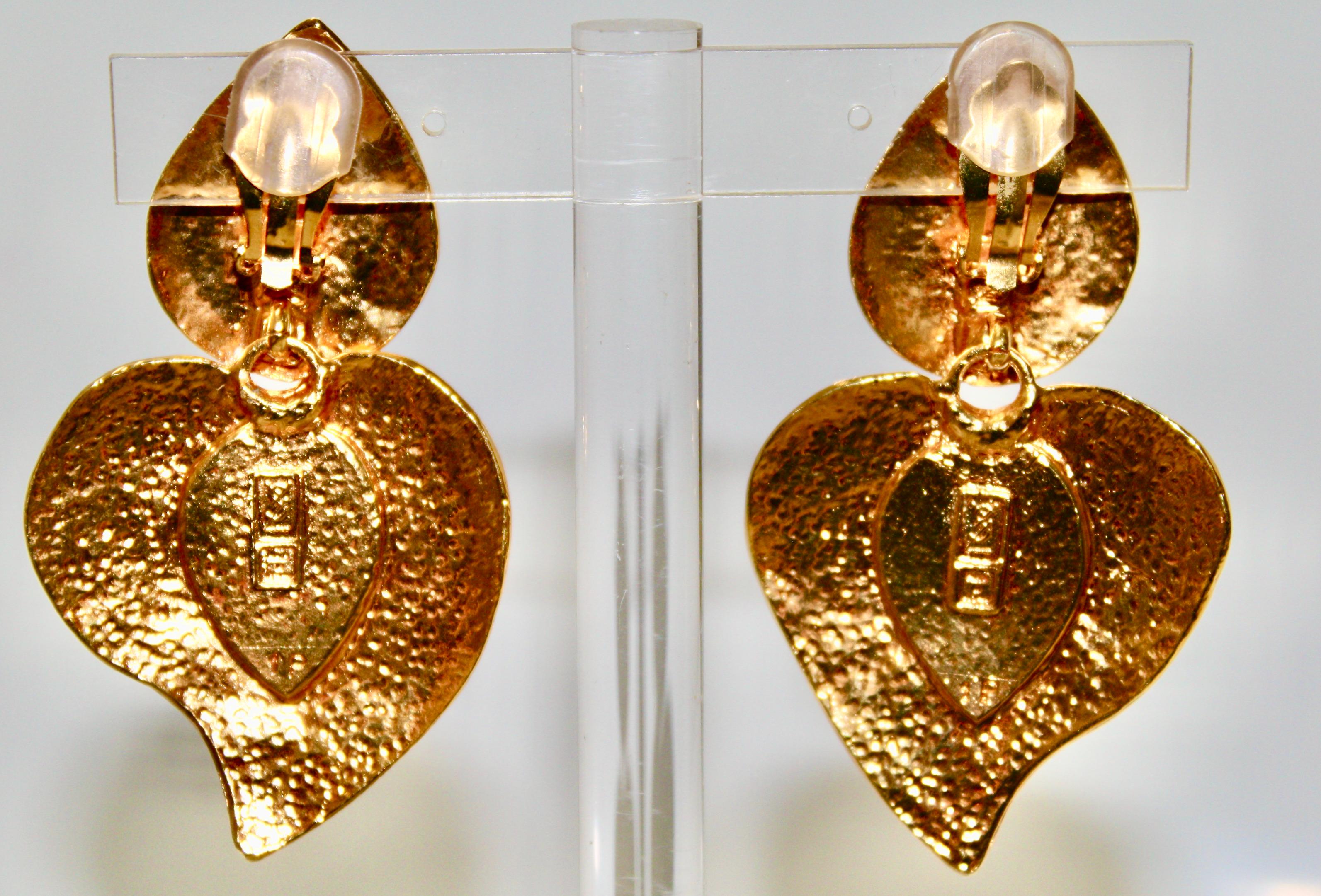 Clip-Ohrringe aus den 80er Jahren. Herz aus rotem Gussglas, gehämmertes, vergoldetes Messingmetall. Unterschrift auf der Rückseite.
Ausgezeichneter Zustand.