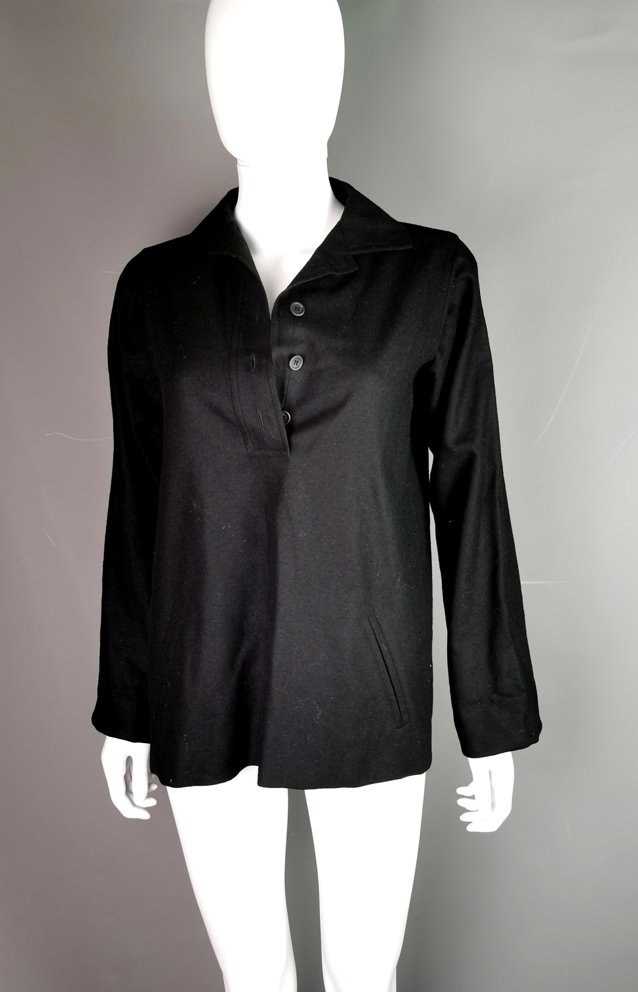 A stylish and versatile vintage YSL Rive Gauche smock style top.

It is a solid black colour with half button up front, buttoning with black plastic buttons and it is collared.

It has long sleeves that appear very slightly flared.

A great