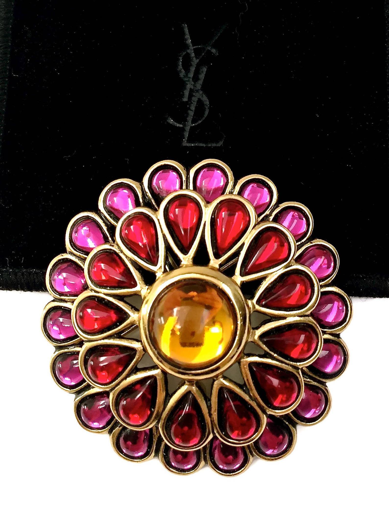 Vintage YSL Yves Saint Laurent Dome Flower Glass Pendant Brooch

Measurements:
Height: 2.16 inches (5.5 cm)
Width: 2.16 inches (5.5 cm)
Thickness: 7.8 inch (2 cm)

Features:
- 100% Authentic YVES SAINT LAURENT.
- Round dome studded with coloured