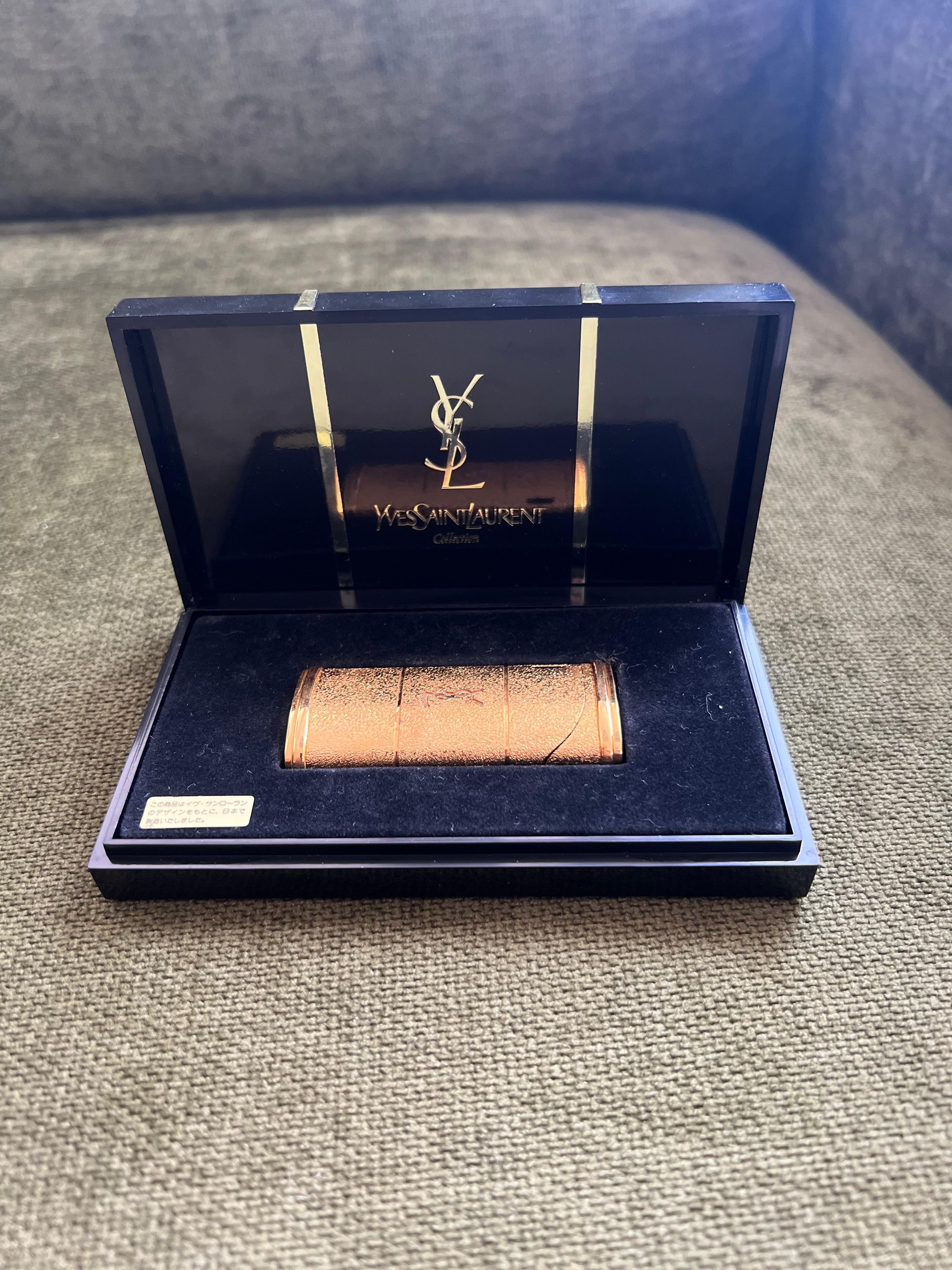 Vintage “YSL” Yves Saint Laurent Retro Cigarette Gold Tone Lighter, Circa 1980s Original Case
“YSL” Yves Saint Laurent retro cigarette lighter 
Logo Gold Black Gray Blue
The Lighter  is in mint condition. Was never used.
In original Yves Saint