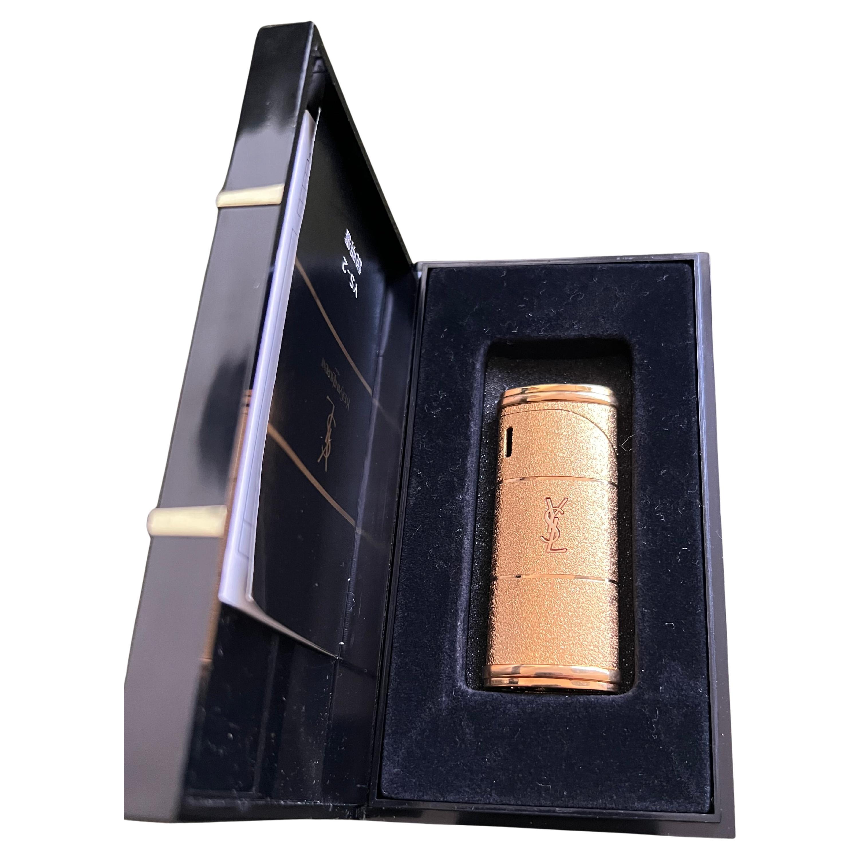 Vintage “YSL” Yves Saint Laurent Retro Cigarette Gold Tone Lighter, Circa 1980s Original Case
“YSL” Yves Saint Laurent retro cigarette lighter 
Logo Gold Black Gray Blue
The Lighter  is in mint condition. Was never used.
In original Yves Saint