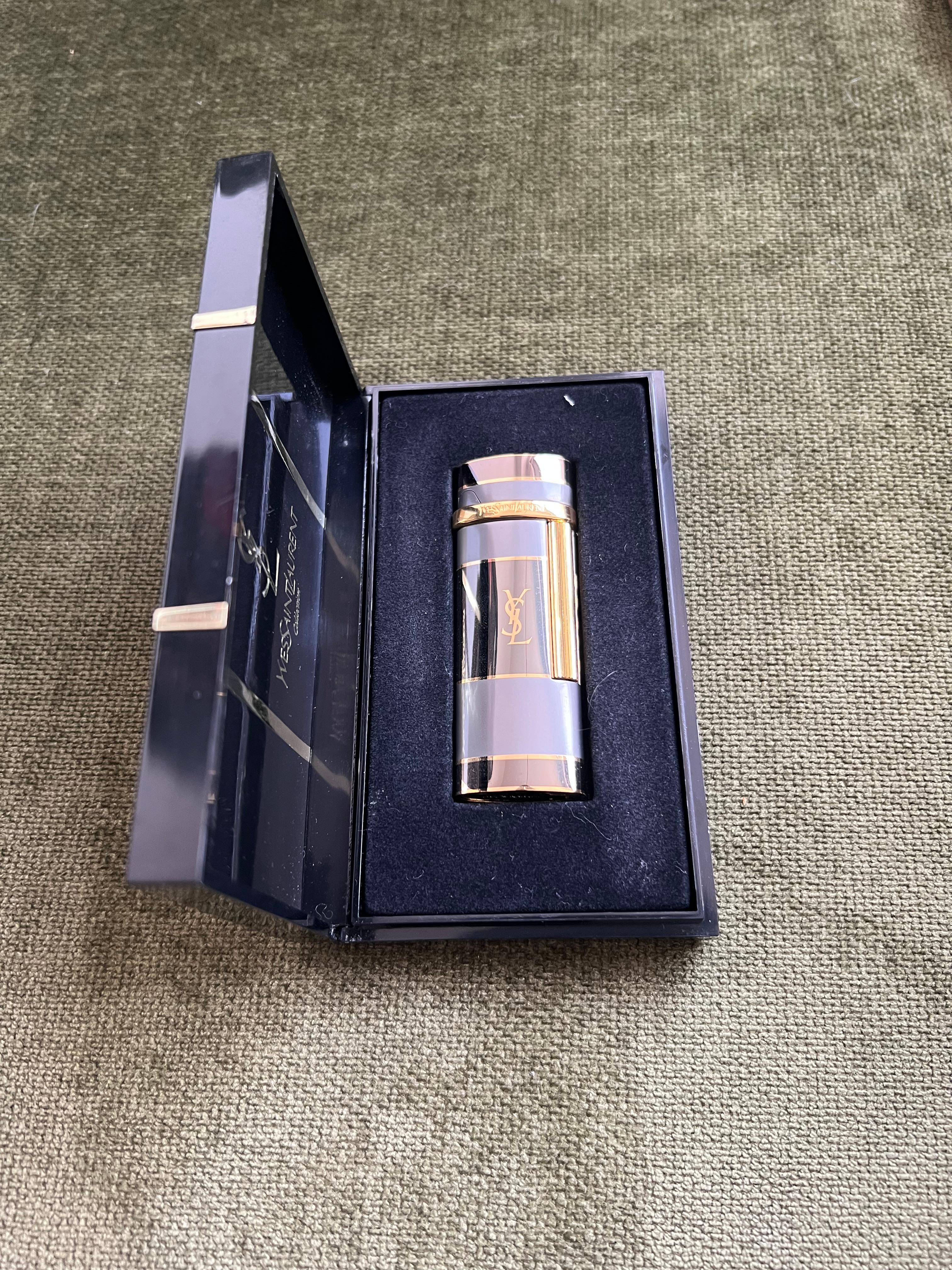 Vintage “YSL” Yves Saint Laurent Retro Cigarette Lighter, Circa 1980s Original Case
“YSL” Yves Saint Laurent retro cigarette lighter 
Logo Gold Black Gray Blue
The Luhgter  is in mint condition. Was never used.
In original Yves Saint Laurent box.