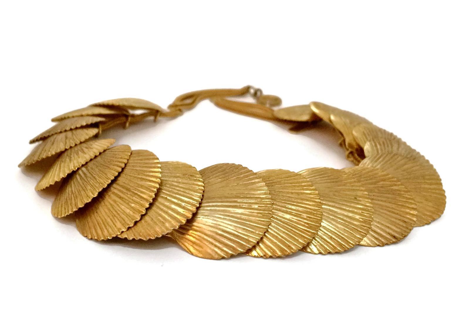 Vintage YSL Yves Saint Laurent Robert Goossens Scallop Shell Choker Necklace

Measurements:
Height: 1.02 inches (2.6 cm)
Wearable Length: 14.17 inches (36 cm)

Features:
- 100% Authentic YVES SAINT LAURENT.
- Textured scallop shell link necklace.
-