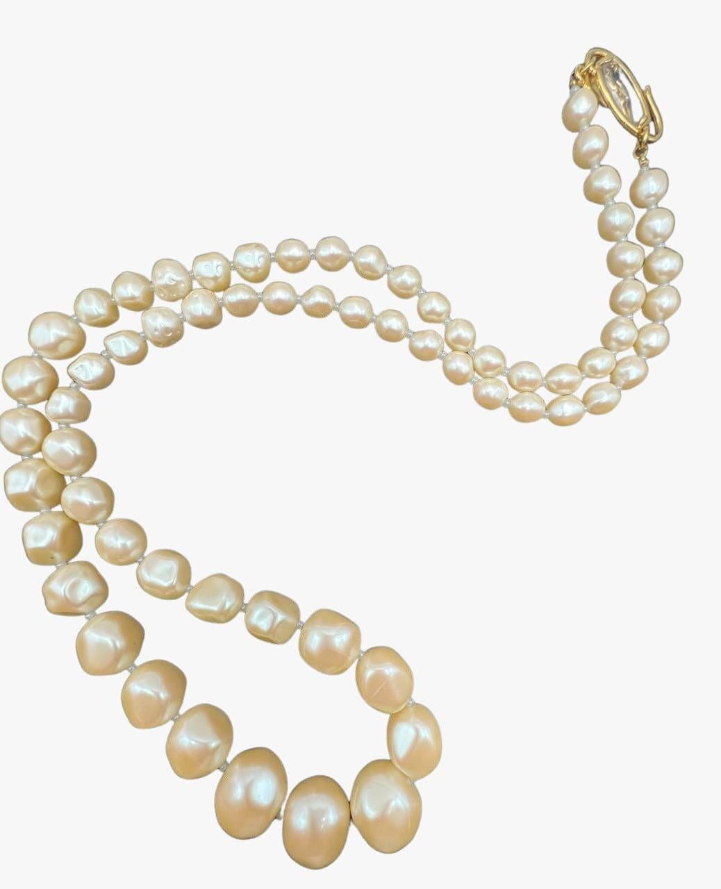 Vintage Yves Saint Lauren necklace made of graduated beads imitating baroque pearls in cream color.  Gold-tone YSL hang tag and quartz clasp. 
Signed. 
Period: 1980s
Condition: excellent. No visible signs of wear. 
Size: 76cm

........Additional