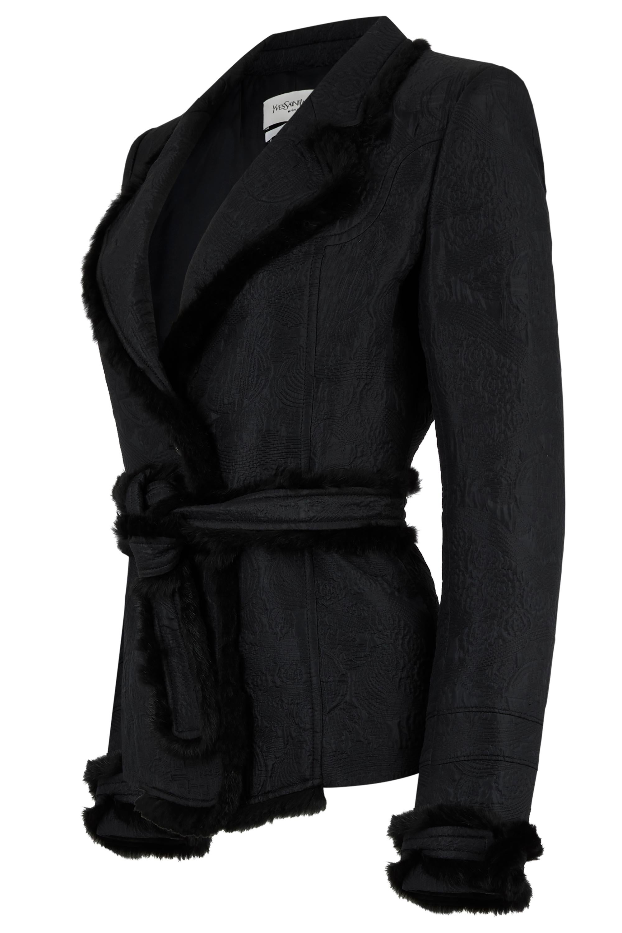 Vintage Yves Saint Laurent Automne Hiver 2004 veste ceinturée en fourrure de vison noir. Confectionnée en jacquard noir, la silhouette est accentuée par des bordures en vison pelucheux le long des revers, des poignets et de l'ourlet. Ceinture