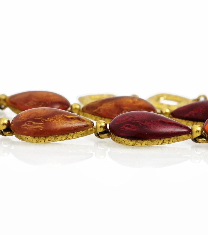 Vintage Yves Saint Laurent Amber Ruby Cabochon Necklace

Measurements:
Height: 5/8 inch
Wearable Length: 14 4/8 inches until 16 4/8 inches

Features:
- 100% authentic YVES SAINT LAURENT.
- Amber and ruby cabochon linked necklace.
- YSL inscriptions