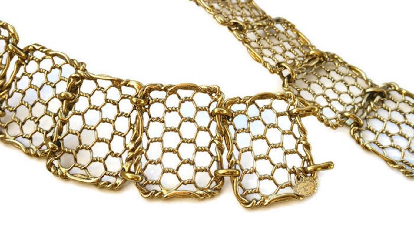 Vintage YVES SAINT LAURENT Articulated Mesh Belt

Measurements:
Height: 6.3 cms
Length: 87 cms

Features:
- 100% Authentic YVES SAINT LAURENT.
- Articulated metal belt in gold tone.
- Each squares have twisted wires in form of fences.
- It has some
