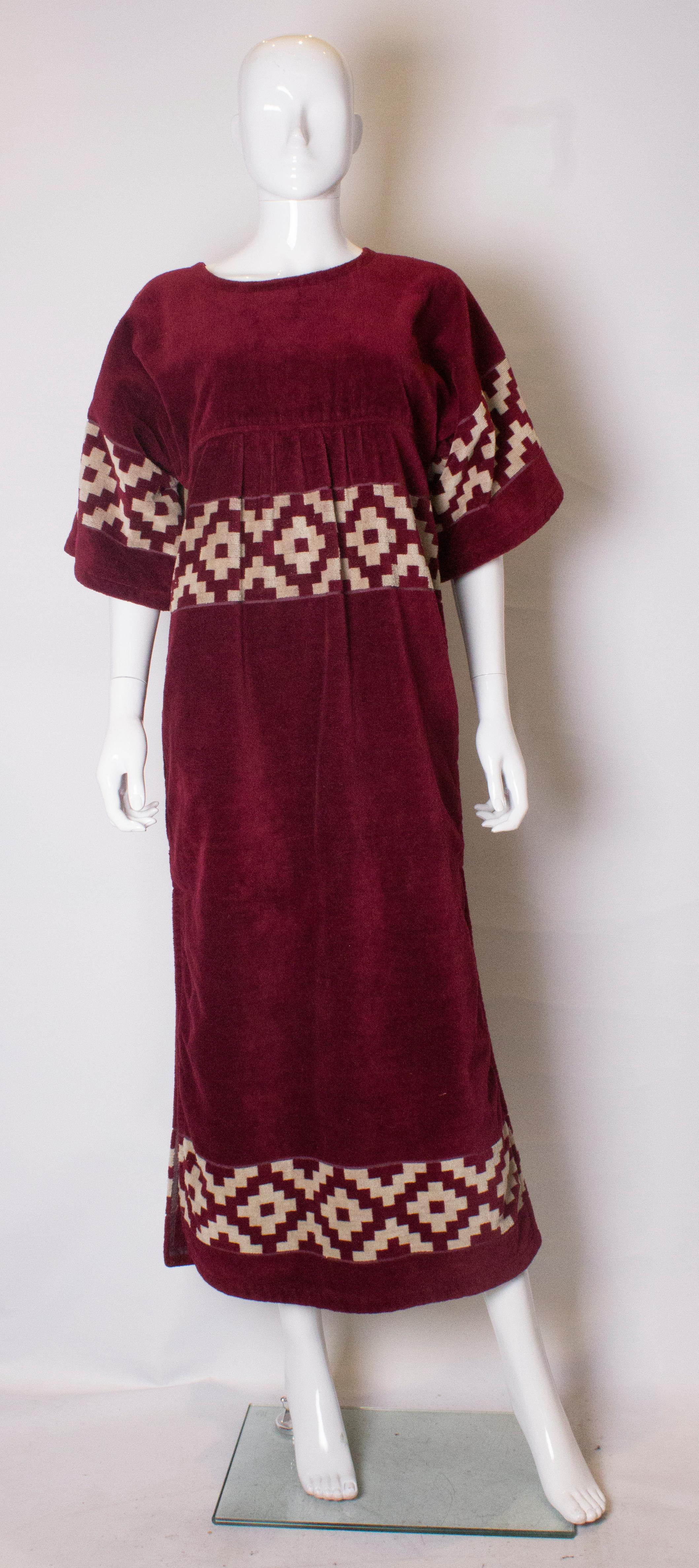 A chic and useful towelling vintage beach cover up Yves Saint Laurent. The robe is in an ivory and burgundy colour with a zip opening at the back , 20'' slit on either side, and a pocket on either side.