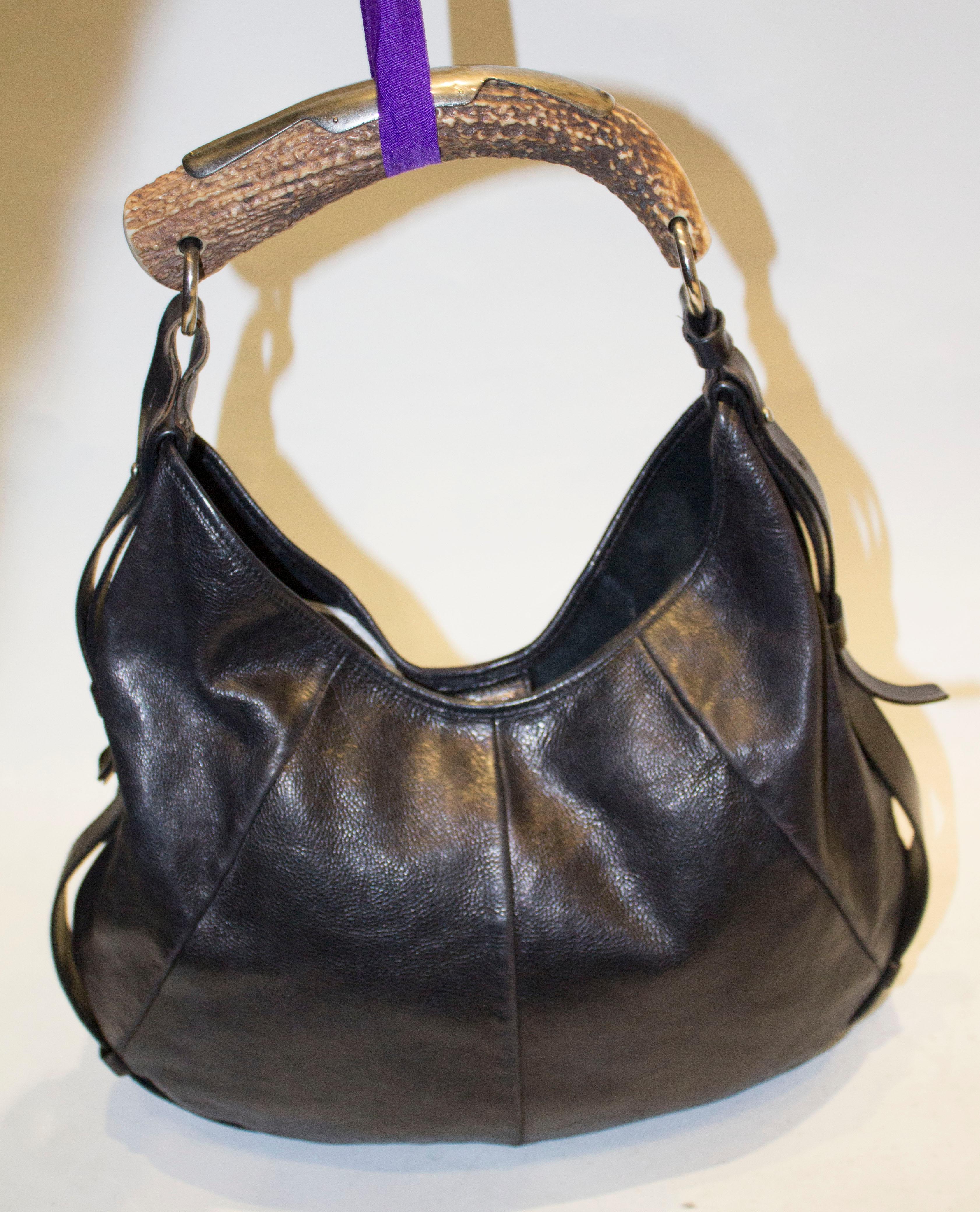Eine schicke YSL Mombasa Hobo Bag aus schwarzem Leder:: mit einem Griff aus Horn und einem verstellbaren Riemen. Die Tasche hat einen Druckknopfverschluss und eine Innentasche mit Reißverschluss. Abmessungen Breite 16'':: Höhe 12'' Tiefe 1''