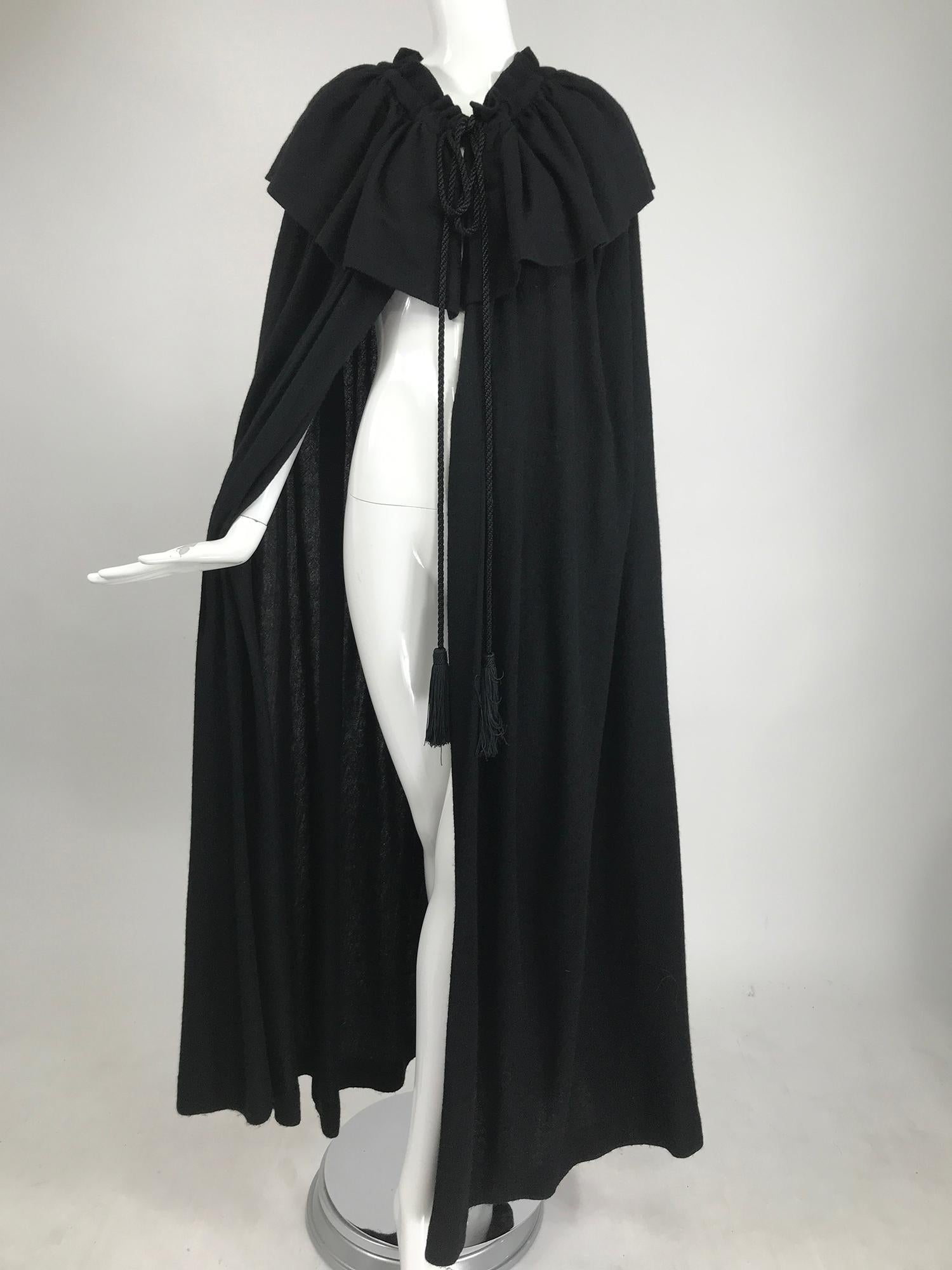 Vintage Yves Saint Laurent, Rive Gauche black wool cape from the 1970s. Lightweight  black wool cape with long silky black tassel end neck ties The ties run through the neck casing and can gather the neck in.  A narrow gathered collar has a deep