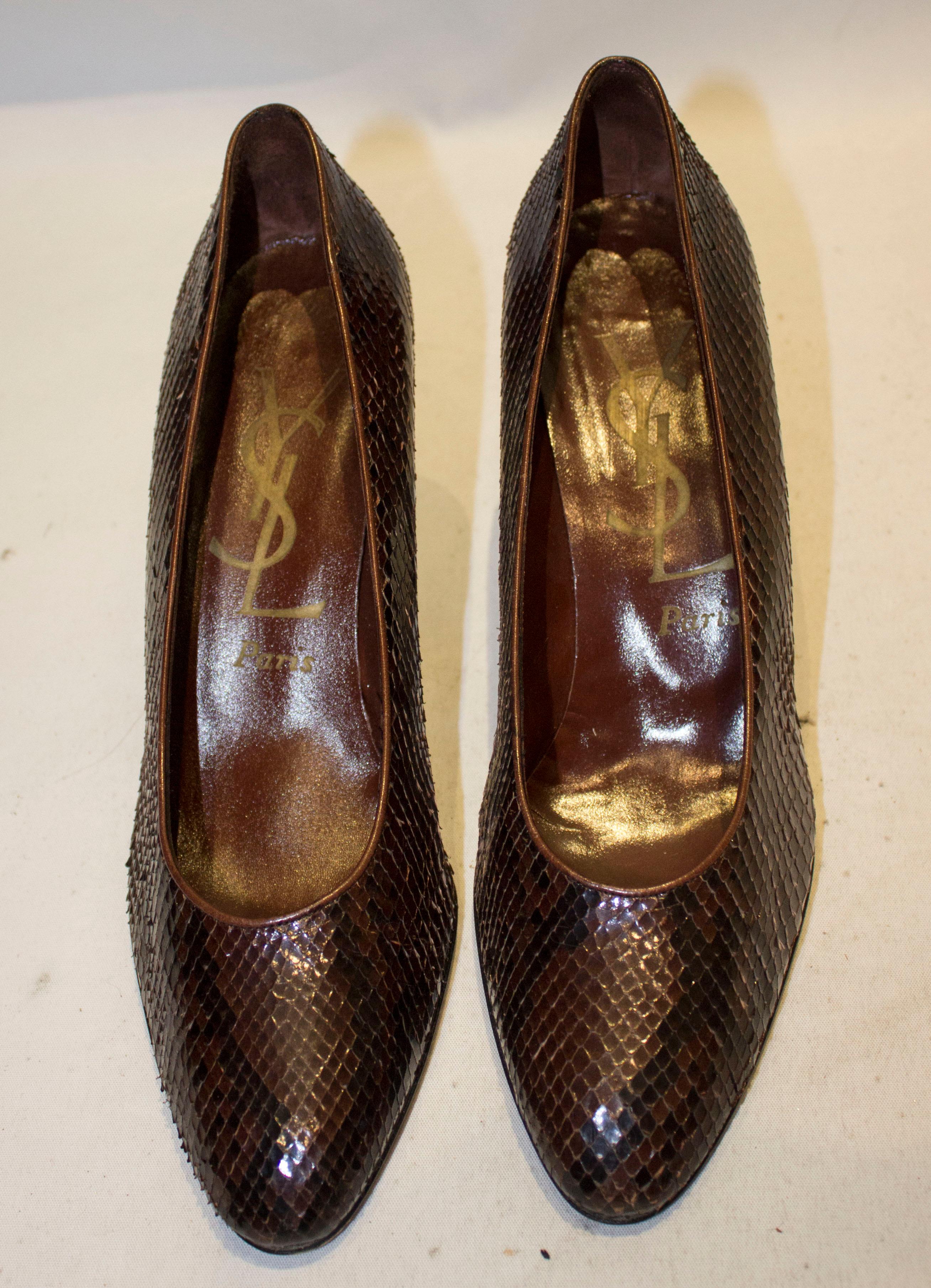 A chic pair of vintage Yves Saint Laurent Paris shoes in brown and black snakeskin. 
The shoes are style 84327, in a size 81 /2 M , with heel height 3 1/2''