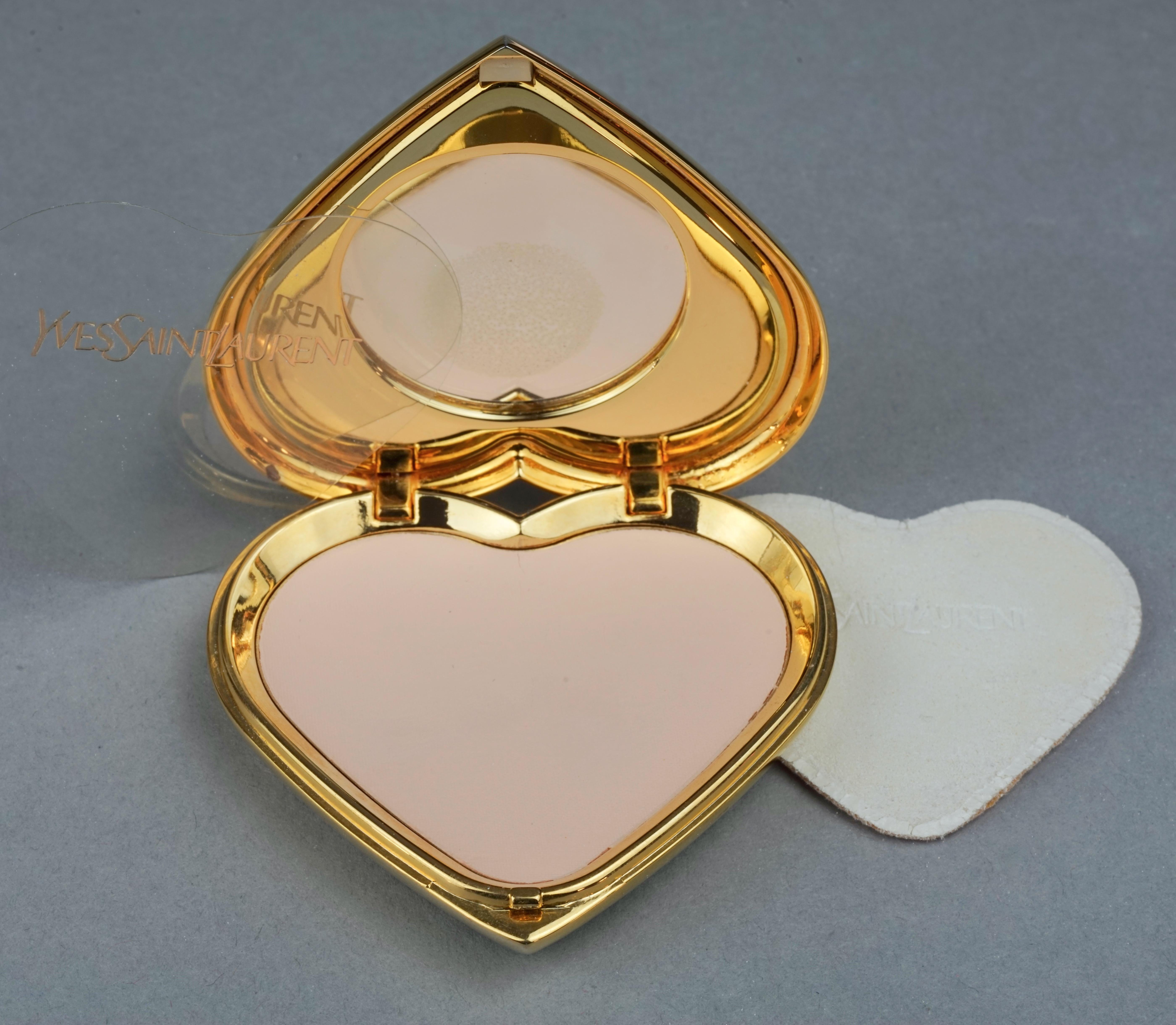 Vintage YVES SAINT LAURENT by Robert Goossens Heart Jewelled Compact Powder

Measurements:
Height: 2.63 inches (6.7 cm)
Width: 2.63 inches (6.7 cm)

Features:
- 100% Authentic YVES SAINT LAURENT by Robert Goossens.
- Heart clear rhinestone jewelled
