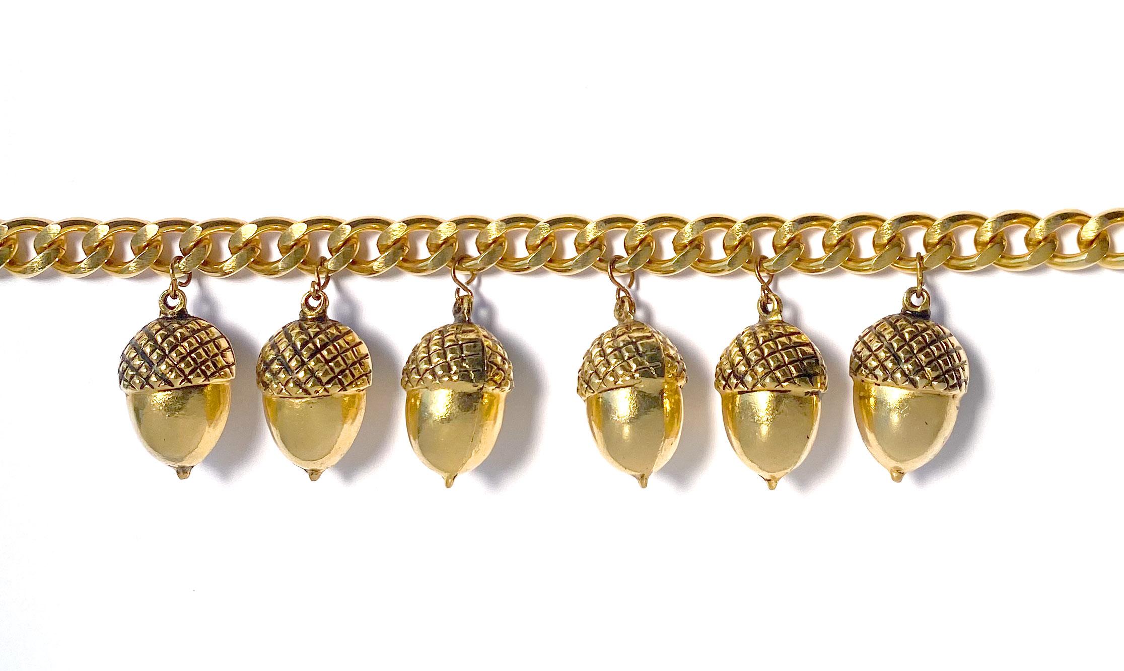 Vintage 1980s Yves Saint Laurent necklace in gold plate.  This heritage statement necklace comprises a flat, wide curb chain in a choker length, featuring six acorn pendants.  

The necklace measures 15.25 inches in length with an extension chain of