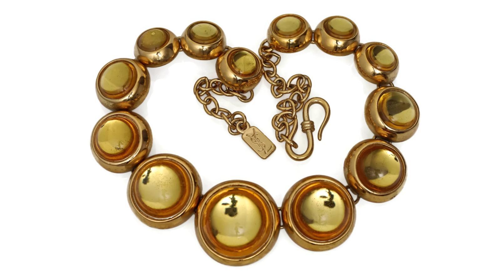 Vintage YVES SAINT LAURENT Citrine Cabochon Necklace

Measurements:
Height: 1 2/8 inches
Depth: 7/8 inch
One Size Fits Most

Features:
- 100% Authentic YVES SAINT LAURENT.
- Dome citrine resin set on gold tone base.
- Gold tone hardware.
-