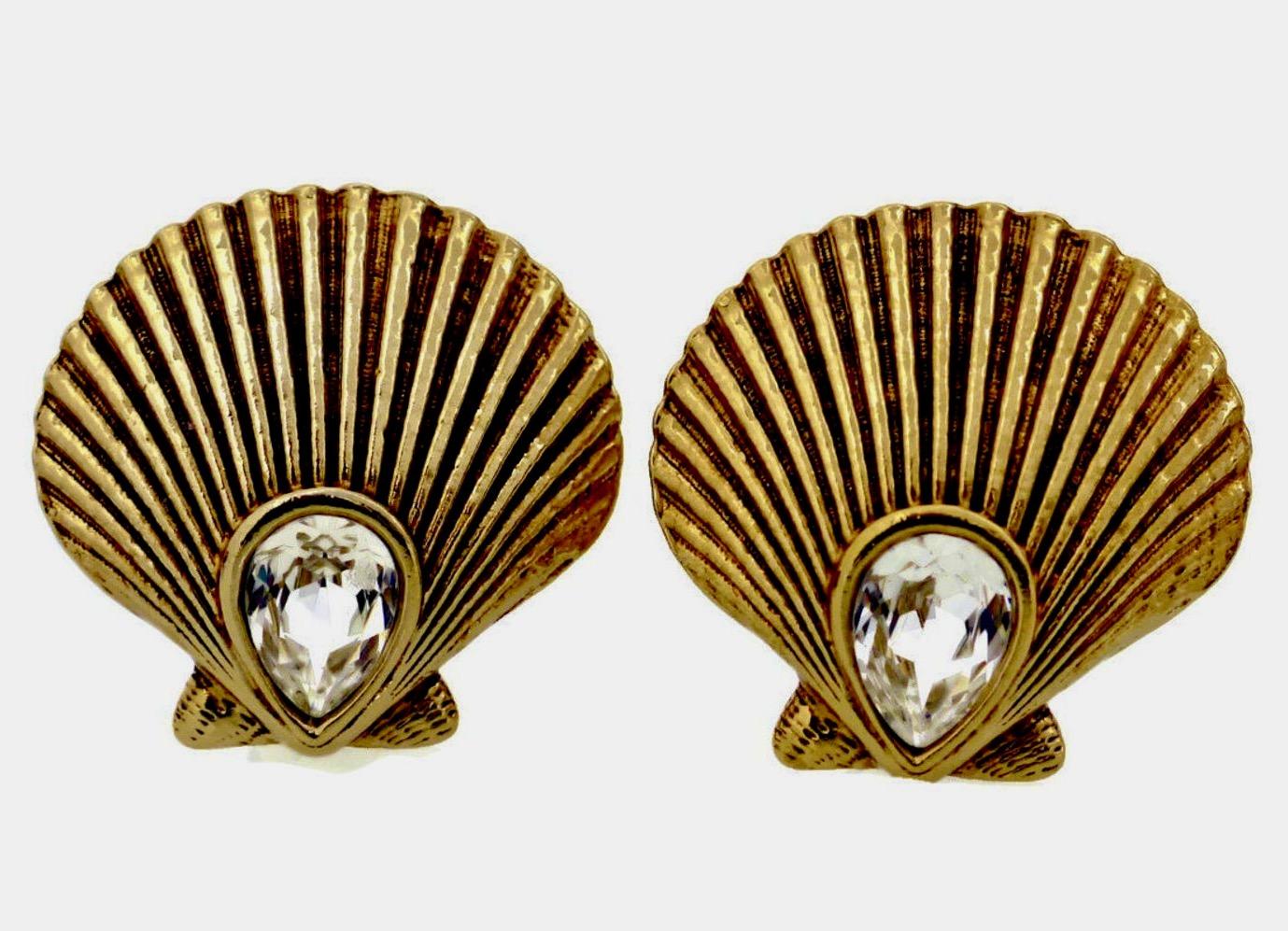 Vintage Yves Saint Laurent YSL Clam Shell Rhinestone Earrings

Measurements:
Height: 1 5/8 inches
Width: 1 5/8 inches

Features:
- 100% Authentic YVES SAINT LAURENT.
- Textured clam shell shape in gold tone.
- Embellished with sparkly faceted