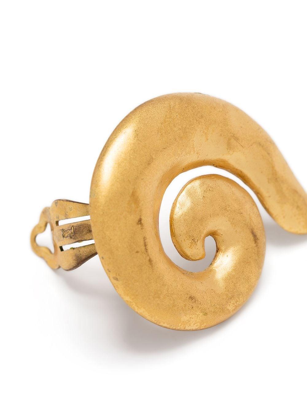 A vintage pair of clip-on earrings from Yves Saint Laurent that exude artisanal elegance. Featuring a spiral design and a clip-on fastening to the back.

Colour: Gold

Material: Gold-plated metal

Measurements: Width: 4.5cm

Pre-owned, excellent