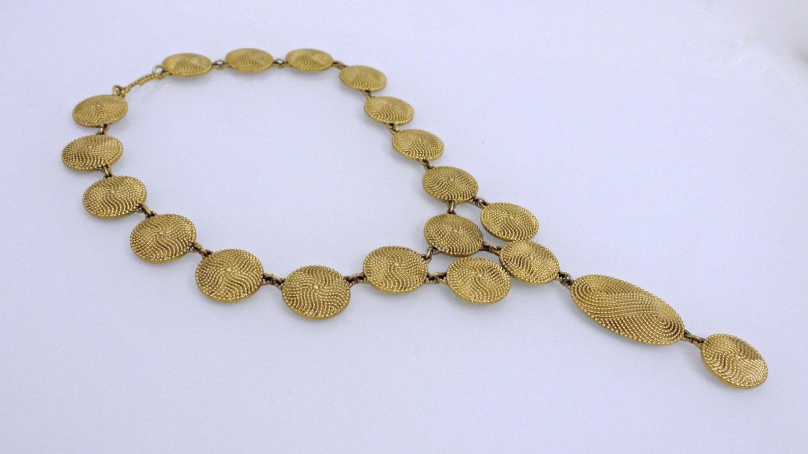 Vintage Yves Saint Laurent Disc Lariat Necklace

Measurements:
Height: 4 6/8 inches (center piece)
Discs: 6/8 inch X 6/8 inch
Wearable Length: 17 inches

Features:
- 100% authentic YVES SAINT LAURENT.
- Dotted discs with wave pattern.
- Articulated