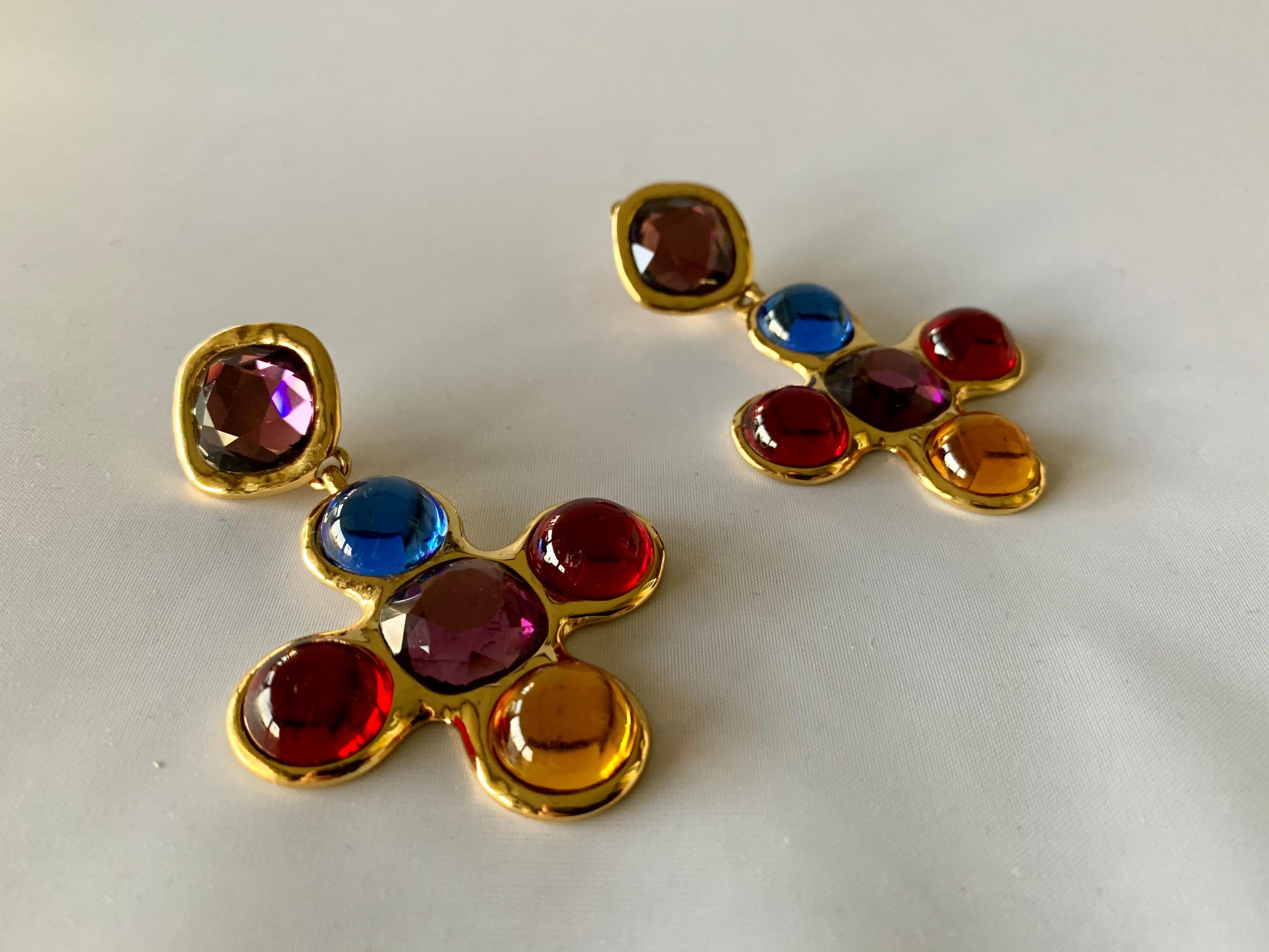 Scarce vintage Yves Saint Laurent gold multi-color cross statement clip-on dangle earrings, made in France by Robert Goossens, circa 1980. The earrings feature faceted and domed glass cabochons in (blue, purple, red, and yellow) are signed YSL, made