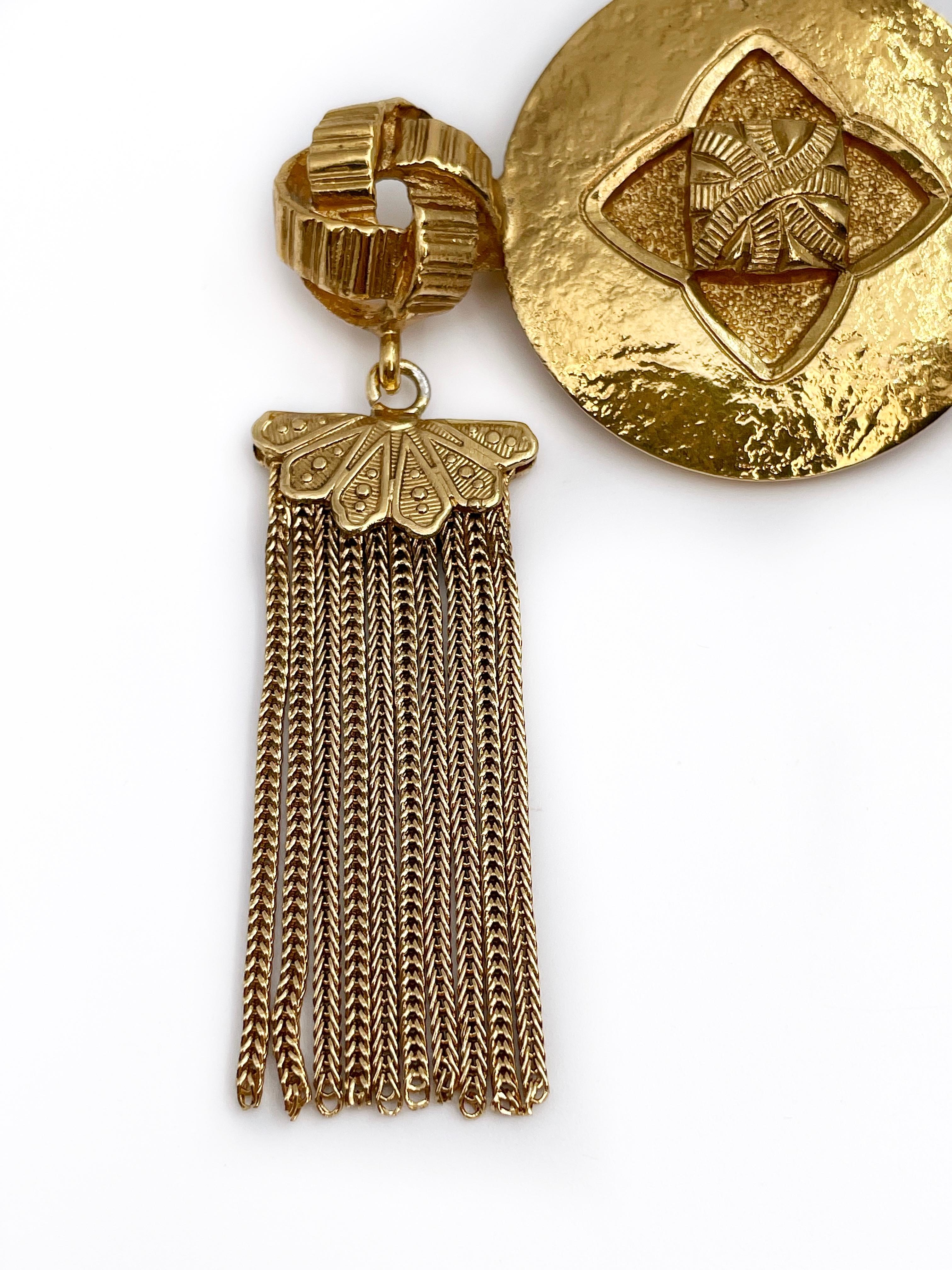 This is an exceptional YSL brooch, which can also be worn as a pendant (there is a loop). The piece is gold plated. Made in 1980’s approximately. 

The design is very dynamic as the hanging tassels are slightly moving while wearing. 

Signature: